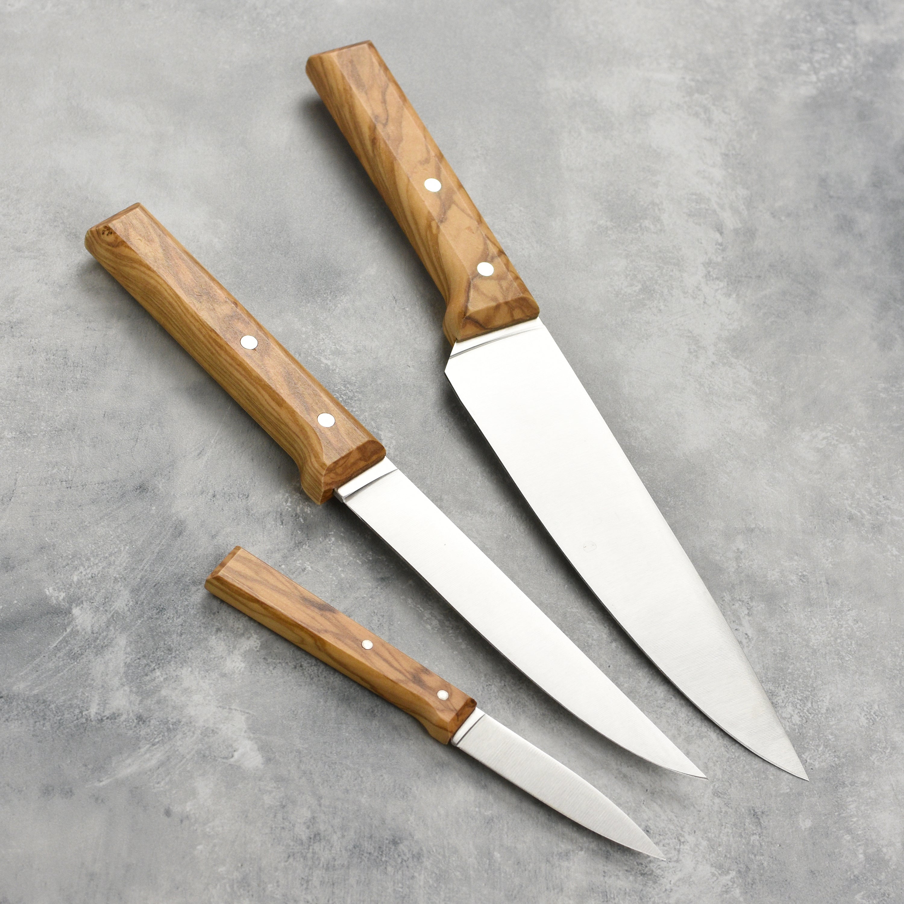 Elegant Olivewood Chef Knife Trio arranged on a wooden cutting board.