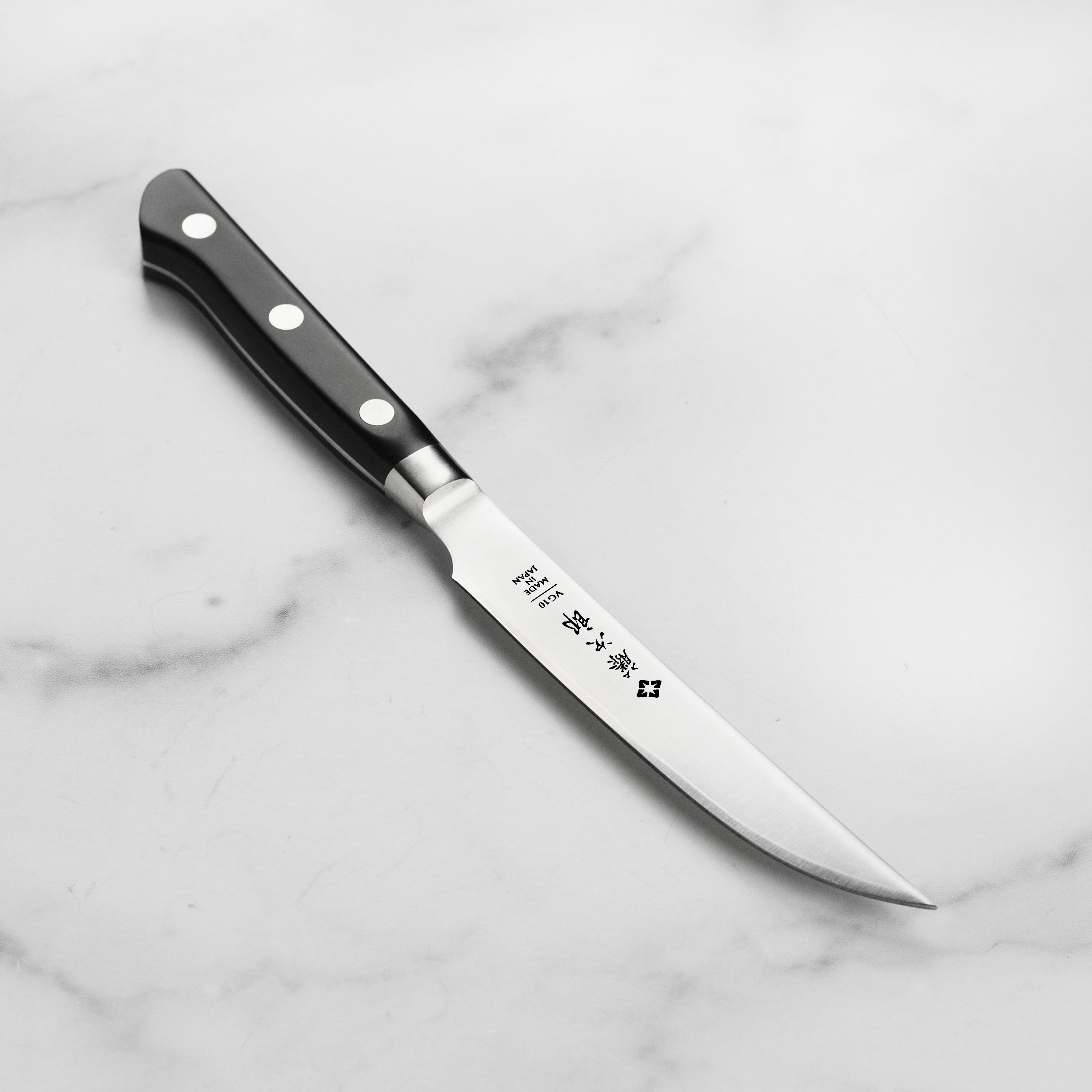 Close-up of the Tojiro Premium Japanese steak knife highlighting the VG-10 super steel core and micarta handle.