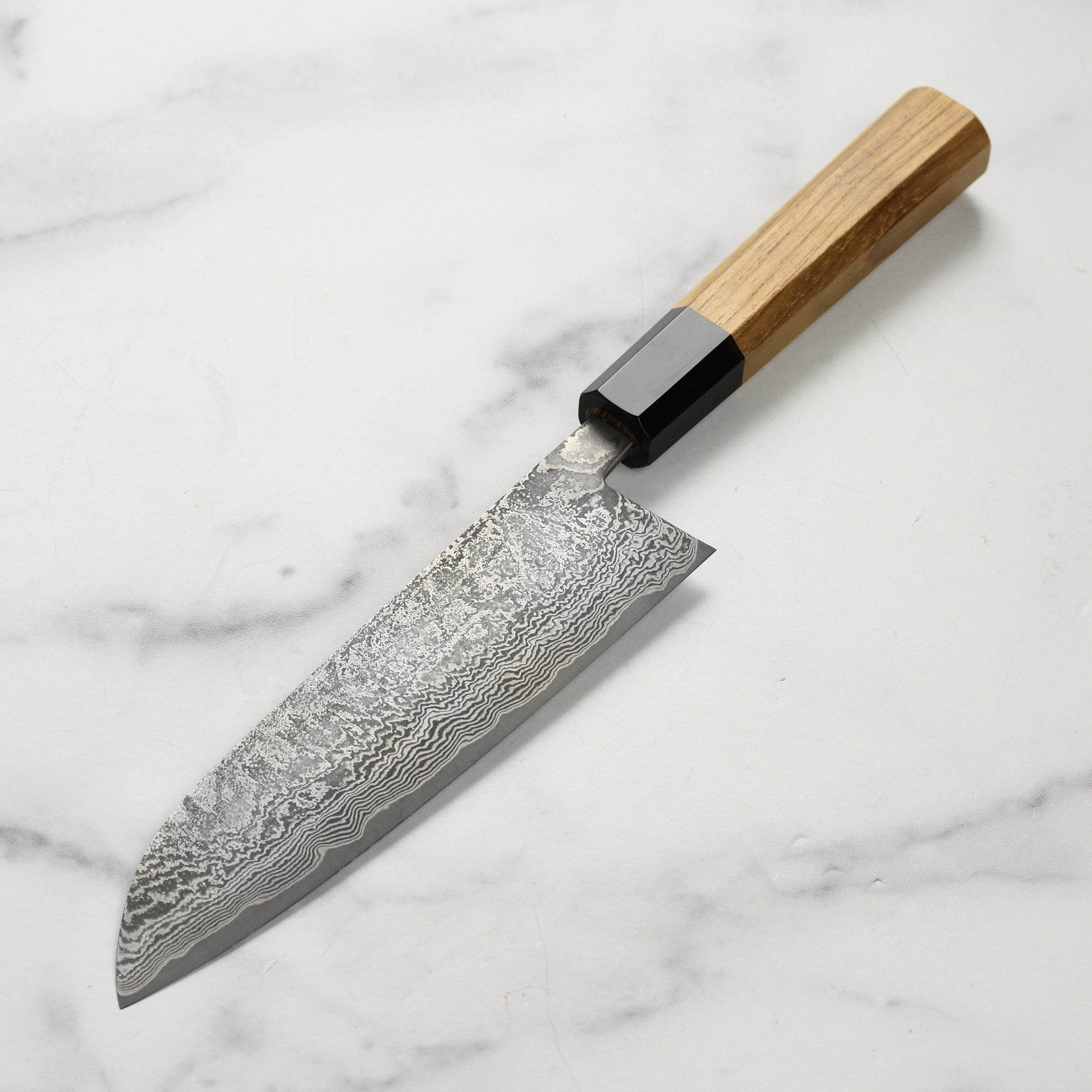 Shiro Kamo Santoku knife in action, expertly slicing vegetables on a cutting board.