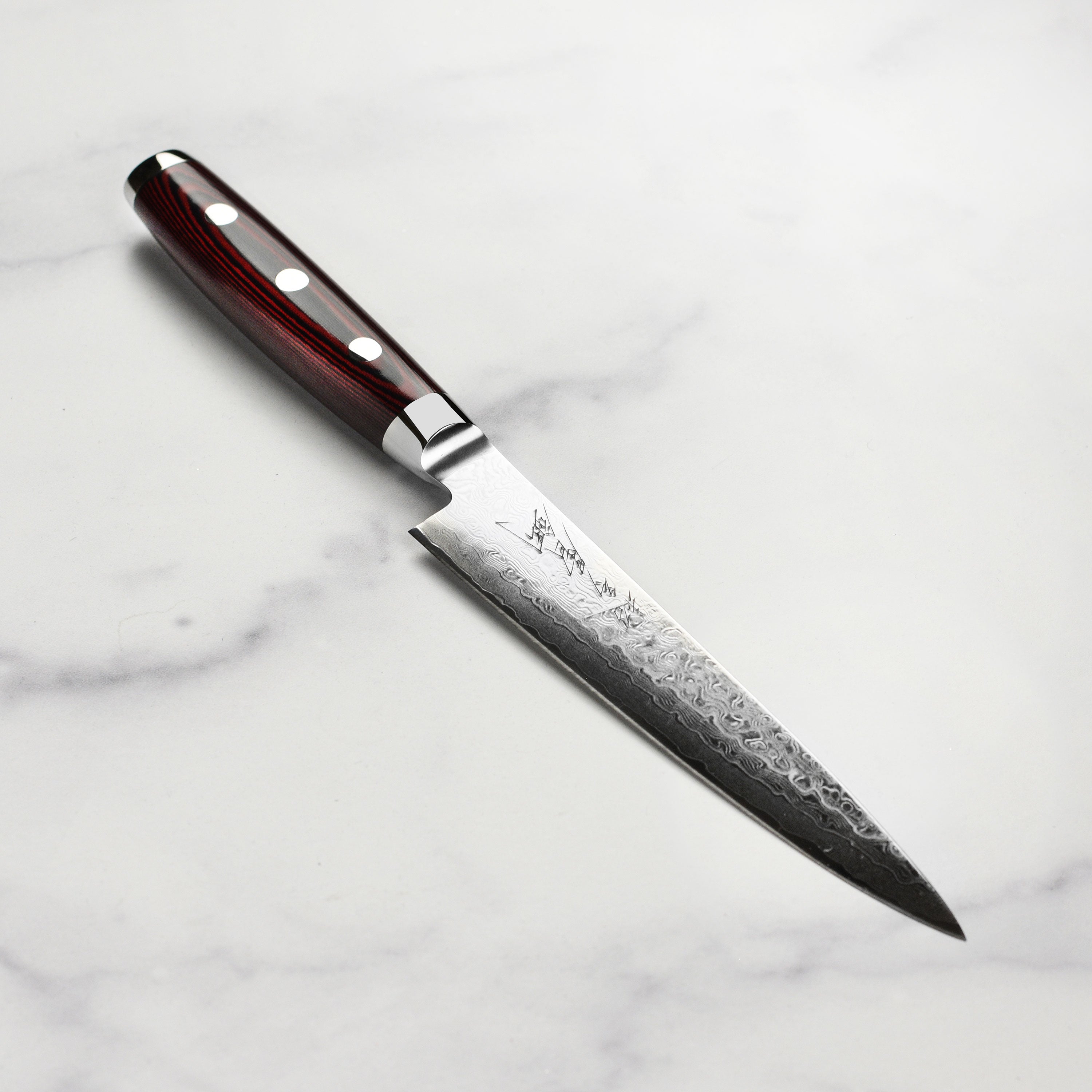 Close-up of the Yaxell Super Gou SG2 utility knife blade, highlighting its 161-layer construction.