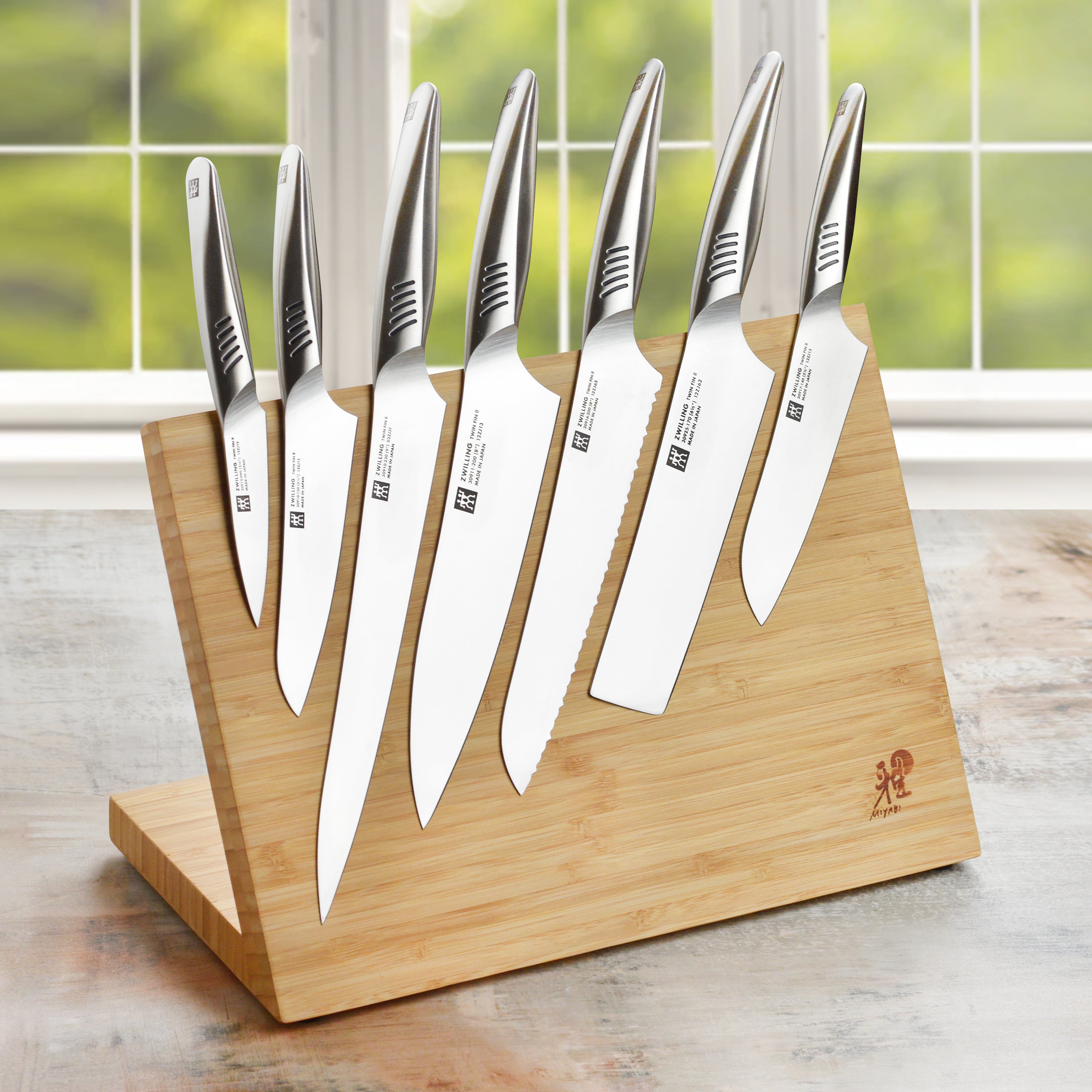 Japanese chef knife set with bamboo handles and stainless steel blades on a cutting board