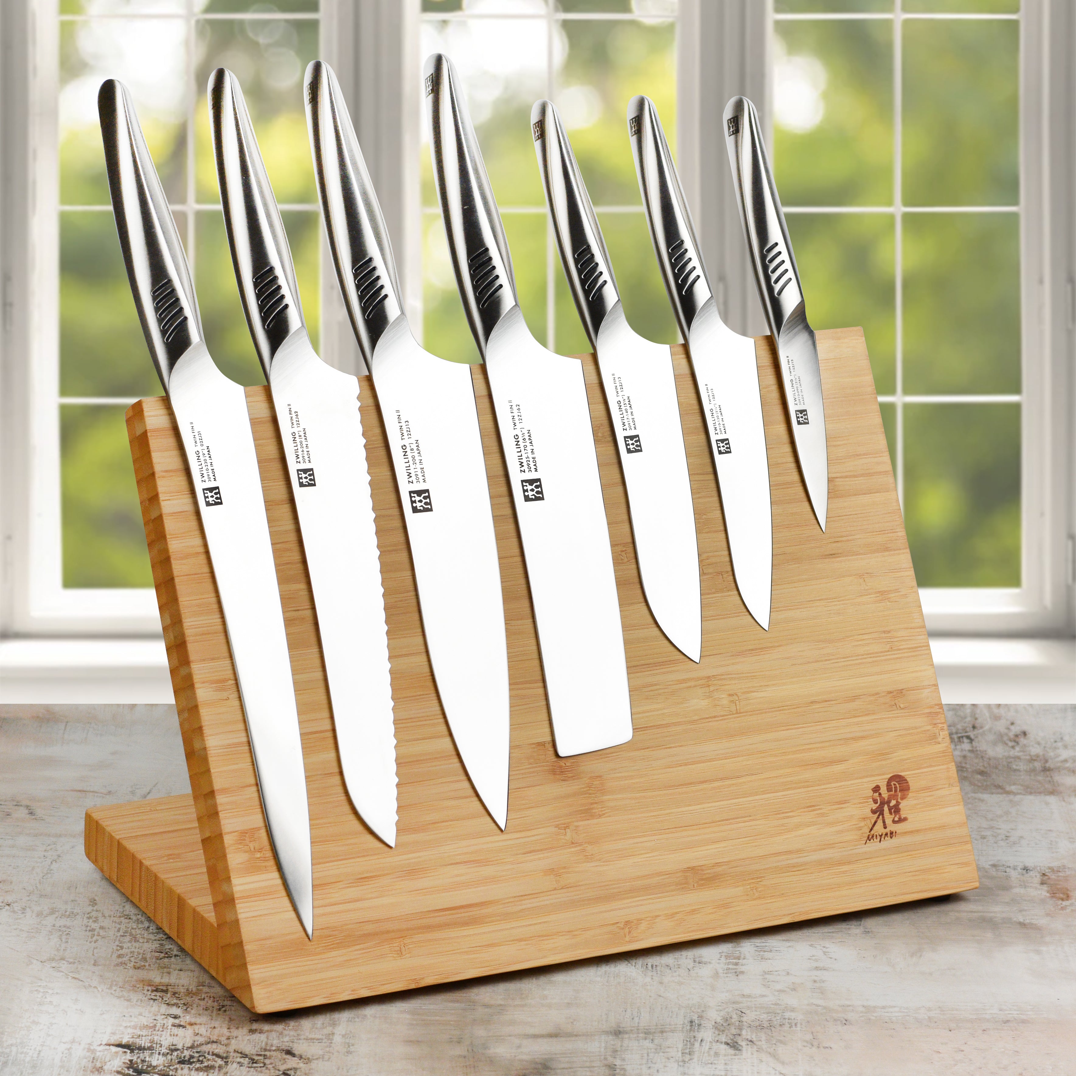 Japanese chef knife set with bamboo handles and stainless steel blades on a cutting board
