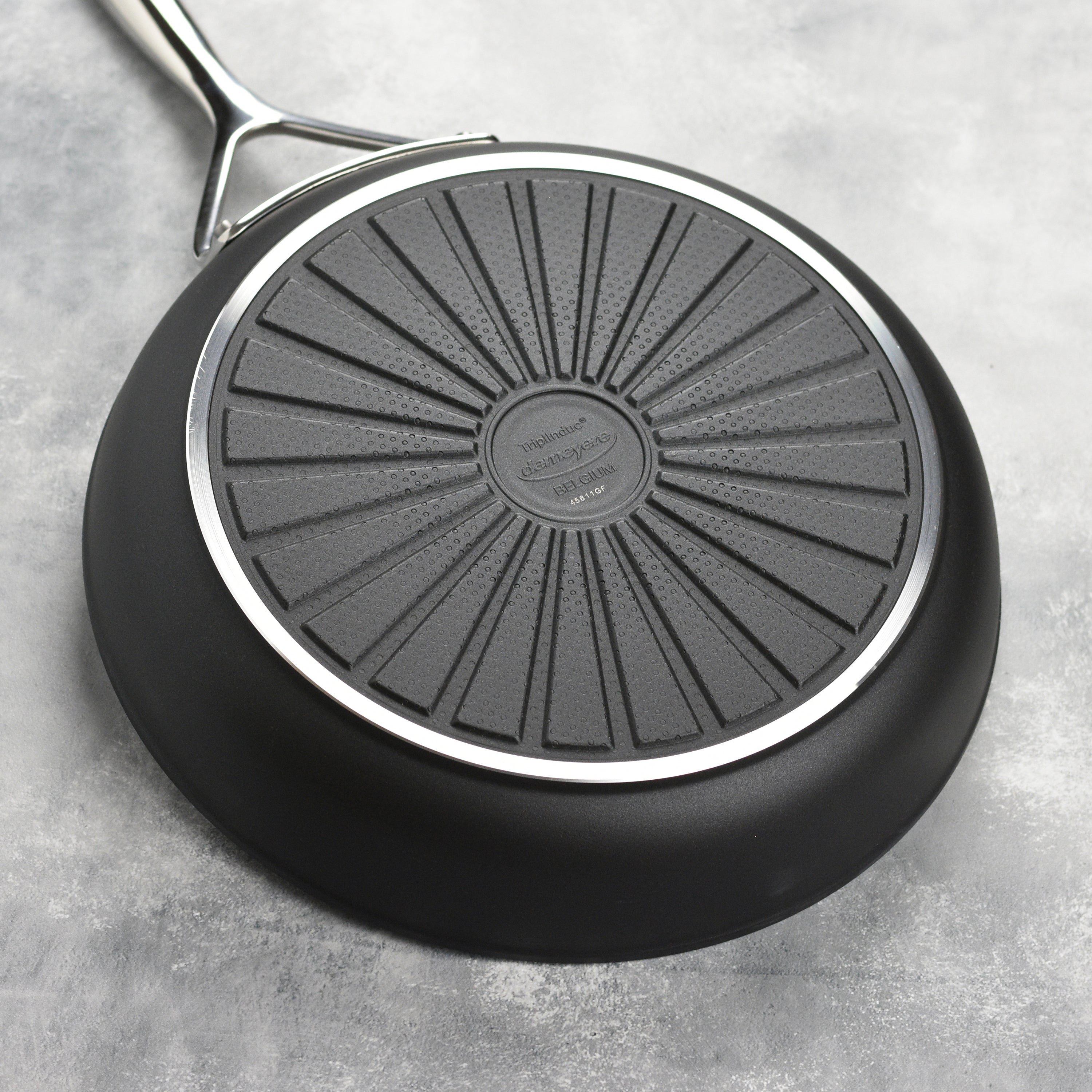 Side view of the Demeyere AluPro frying pan on an induction cooktop, highlighting its compatibility with various cooking surfaces.