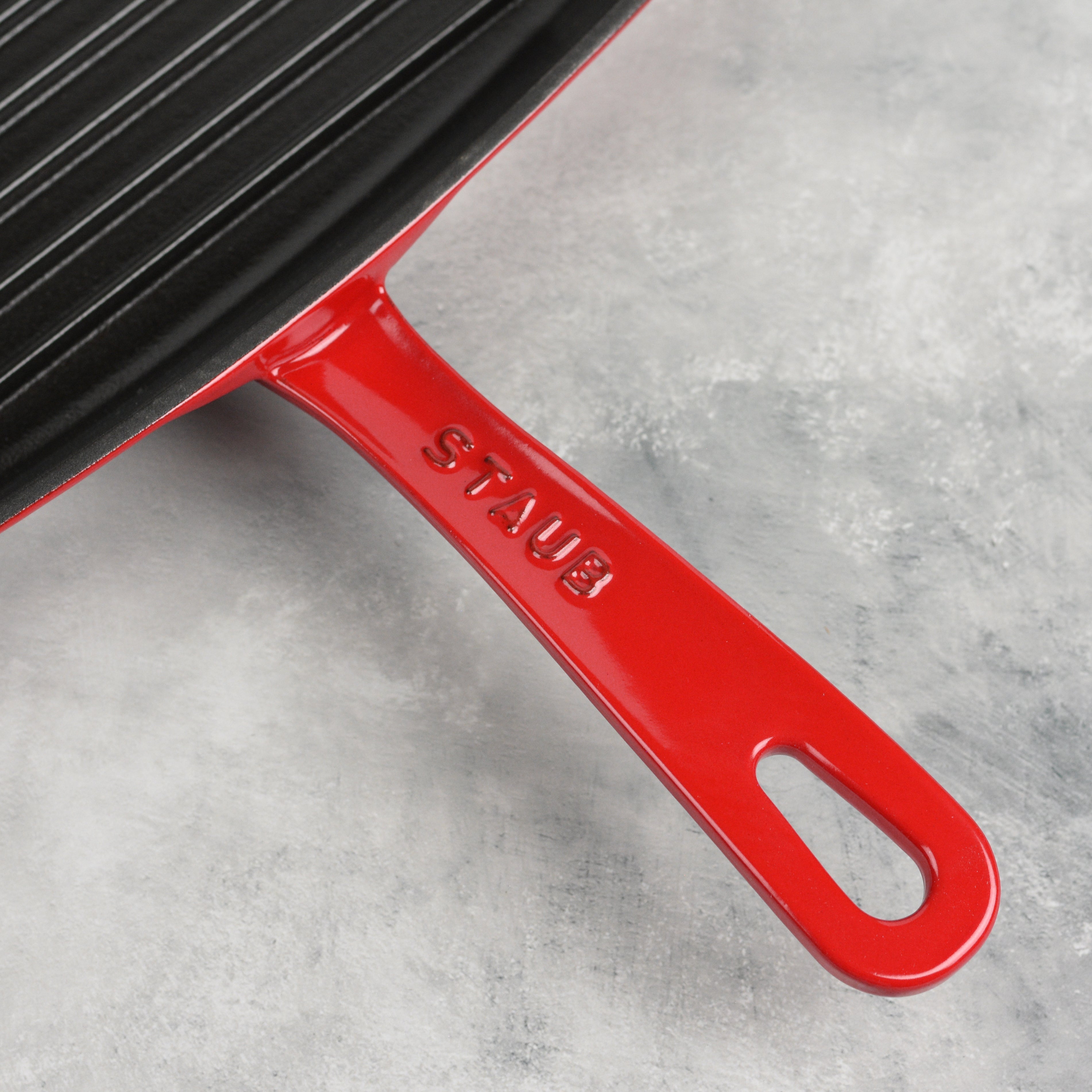 Cherry Red Staub 12-Inch Enameled Cast Iron Grill Pan showcasing its textured interior and grill grooves.