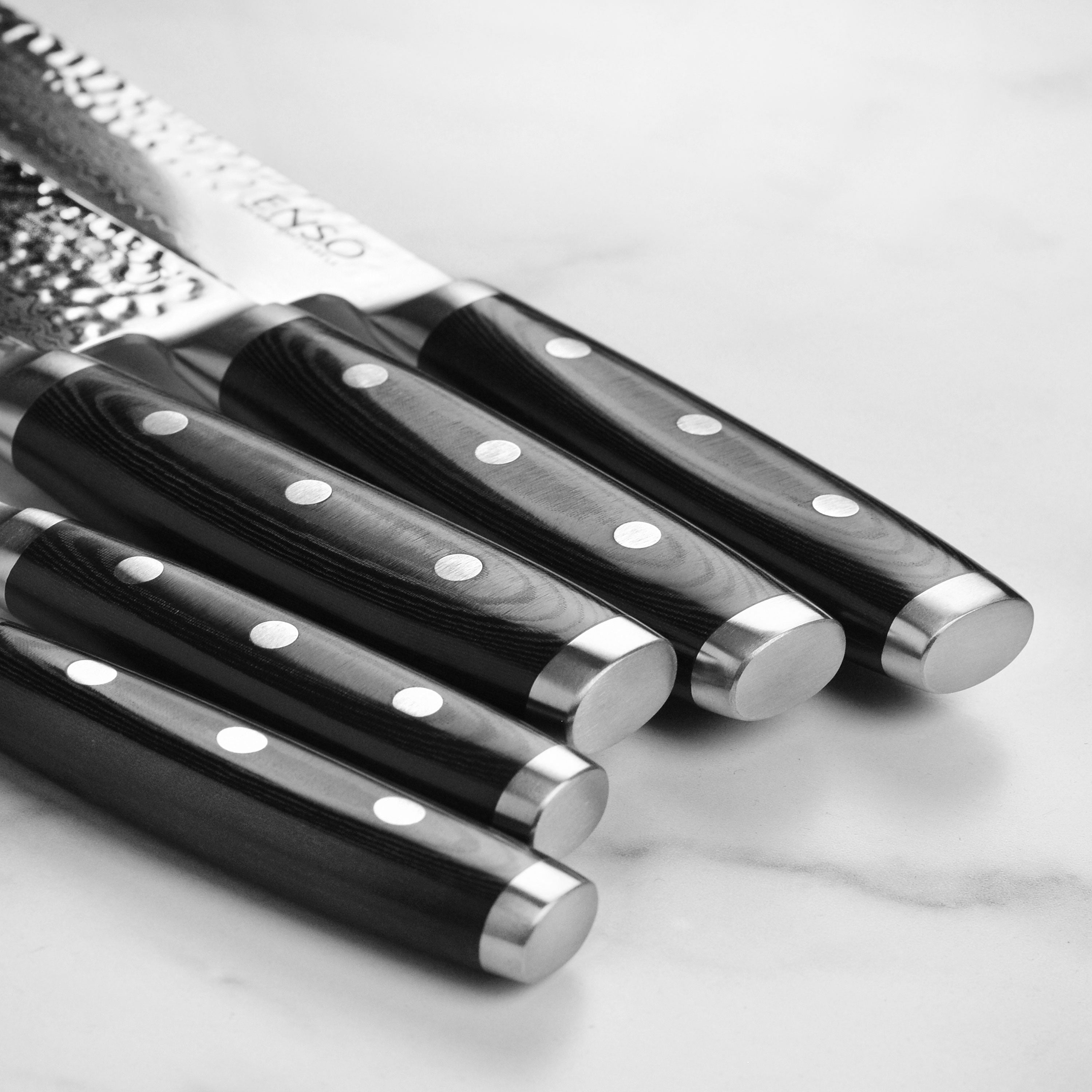 Close-up of the VG-10 steel blade illustrating its sharp edge and hammered finish.