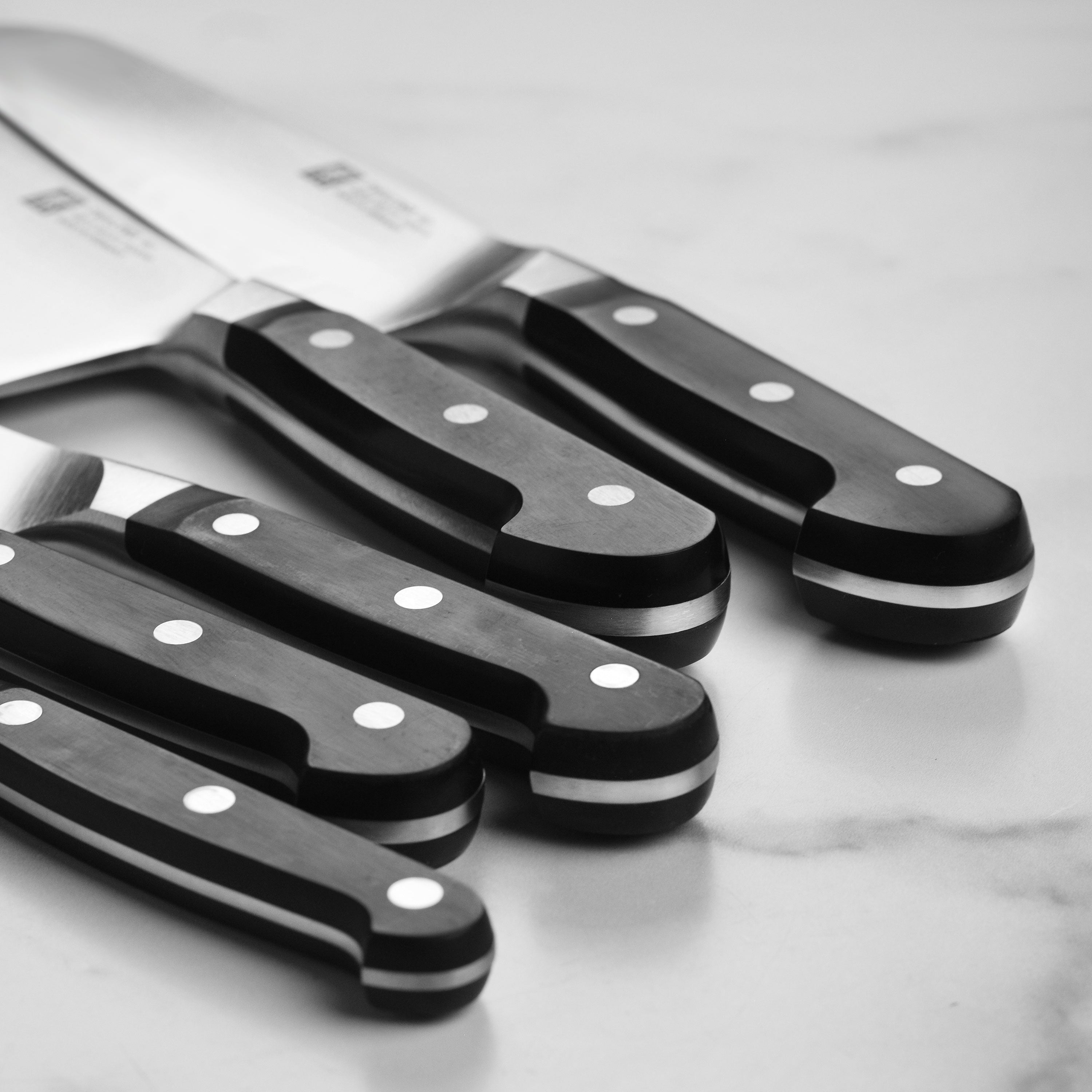 Close-up of the Zwilling high carbon steel knives with a focus on the ergonomic handle and blade finish.