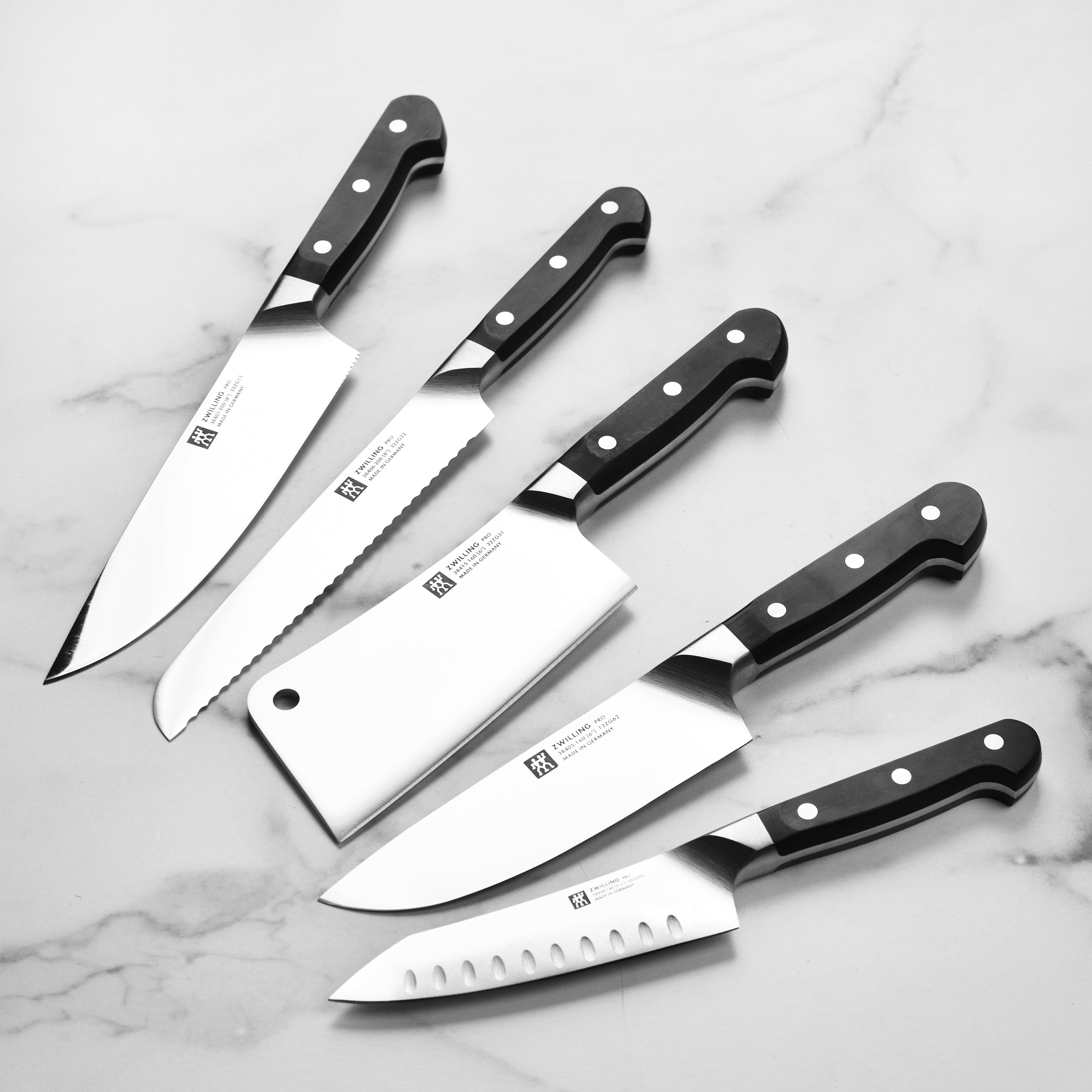Close-up of the Zwilling high carbon steel knives with a focus on the ergonomic handle and blade finish.