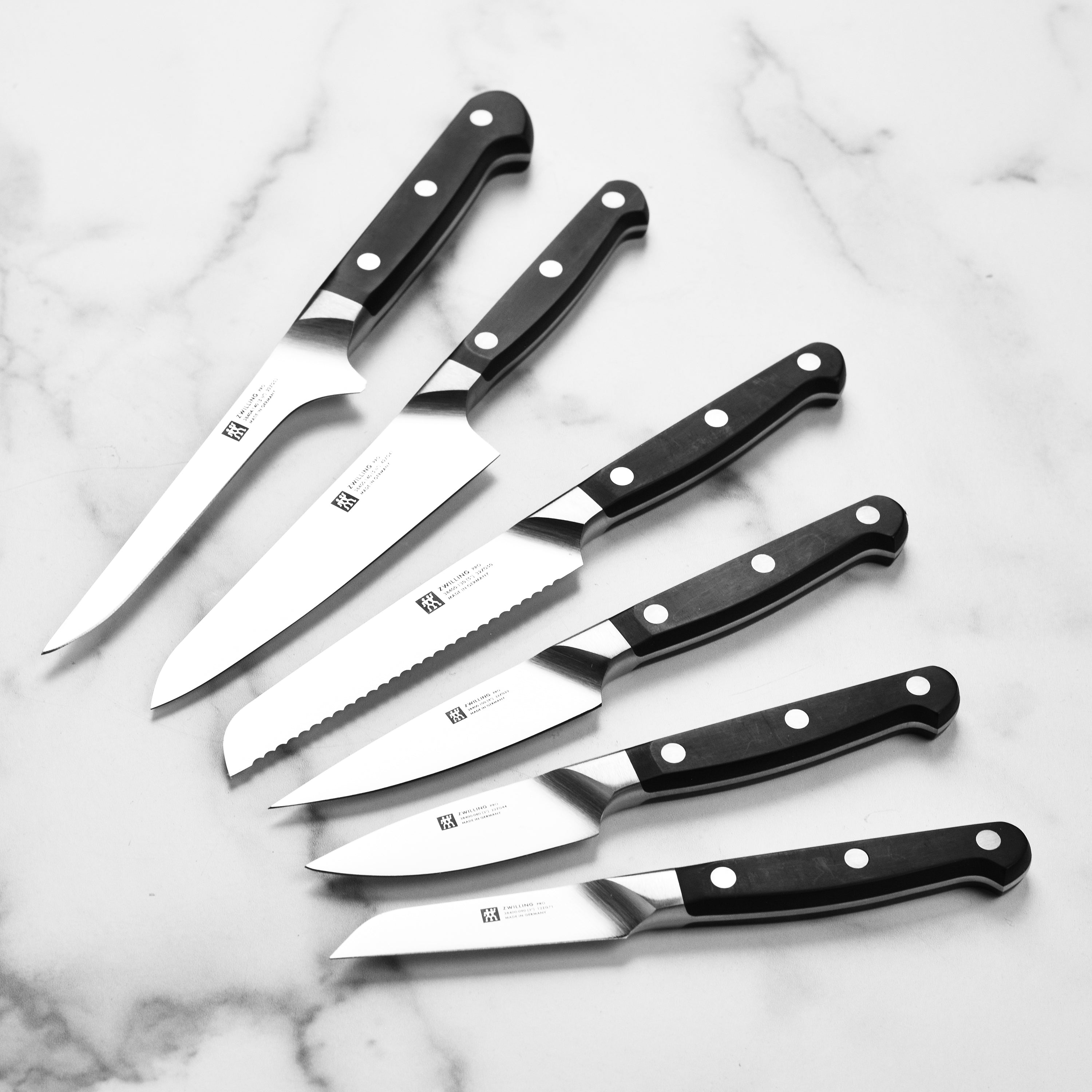 Close-up of the Zwilling high carbon steel knives with a focus on the ergonomic handle and blade finish.