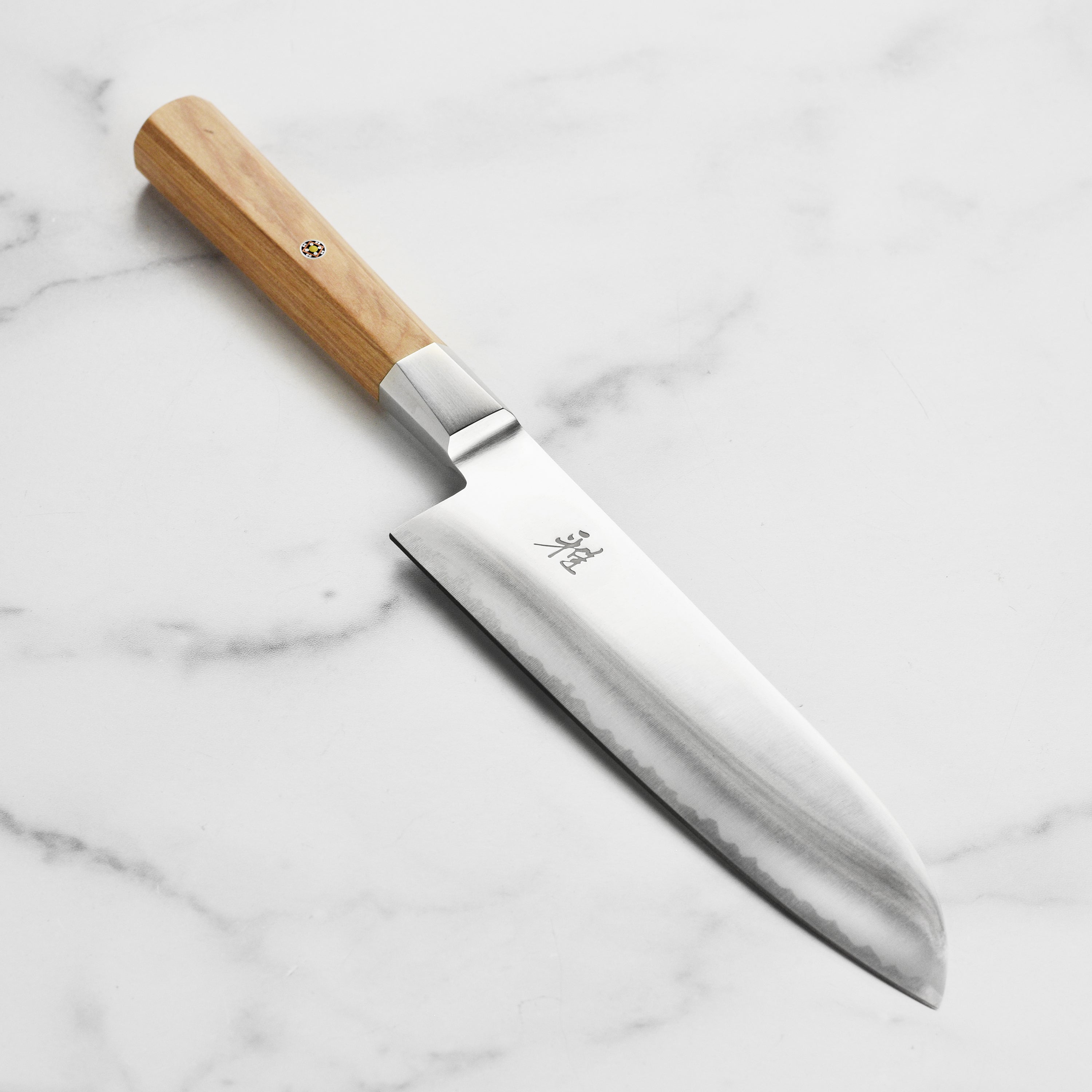 Close-up of Miyabi Koya 7 inch santoku knife blade with engraved logo and Katana edge
