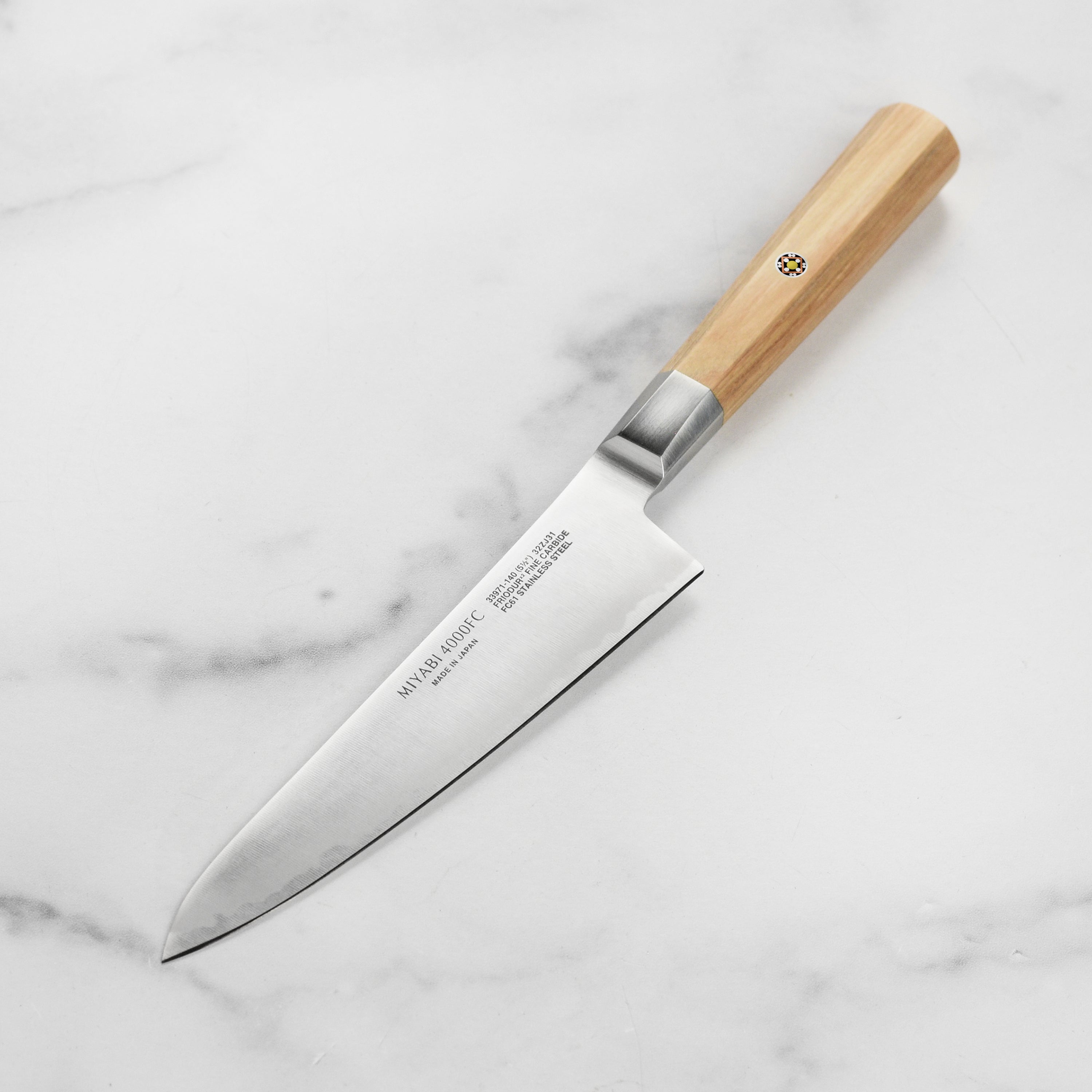 Miyabi Koya knife in action, slicing vegetables on a wooden cutting board