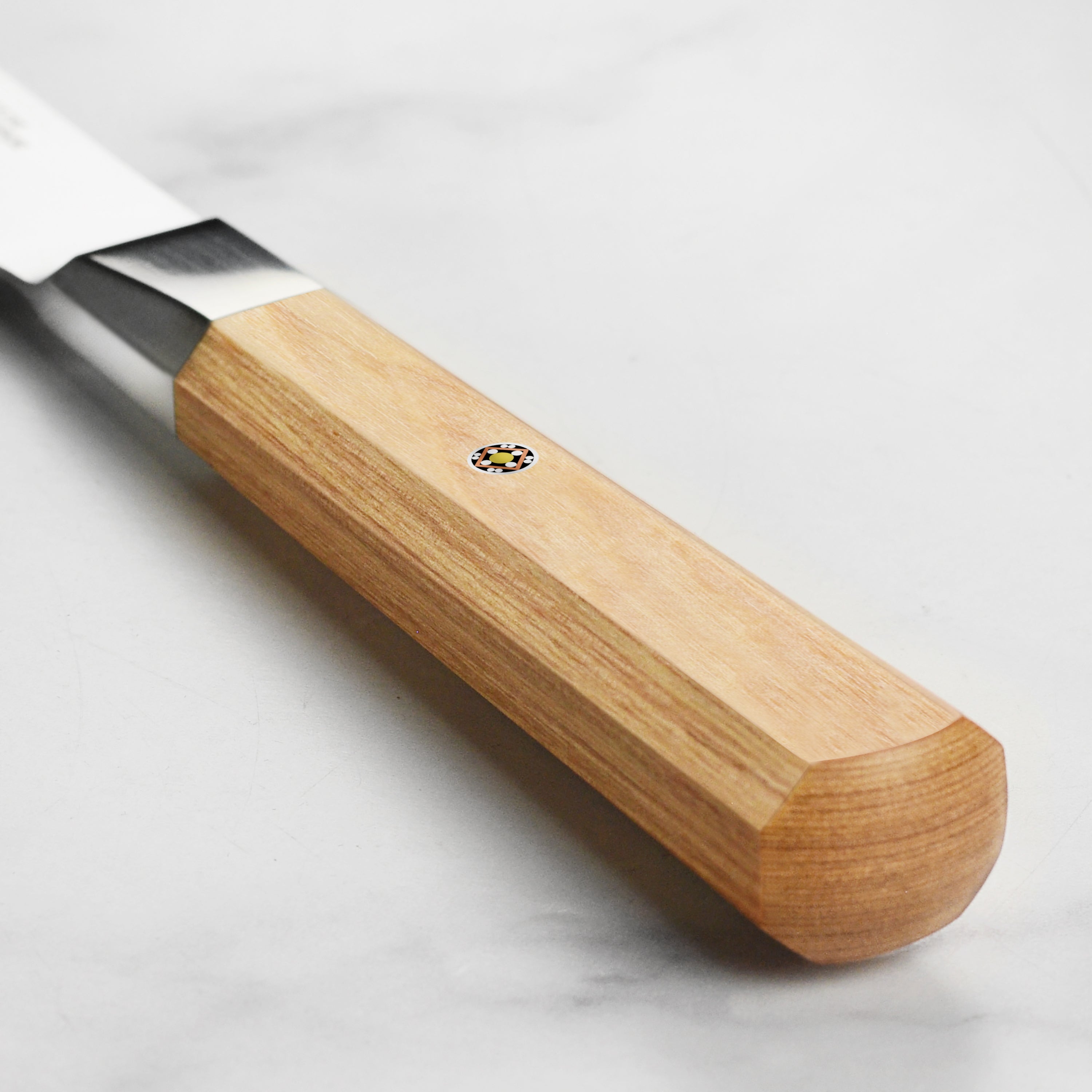 Close-up of the Miyabi Koya Nakiri knifes birchwood pakkawood handle, highlighting the craftsmanship and mosaic accent.