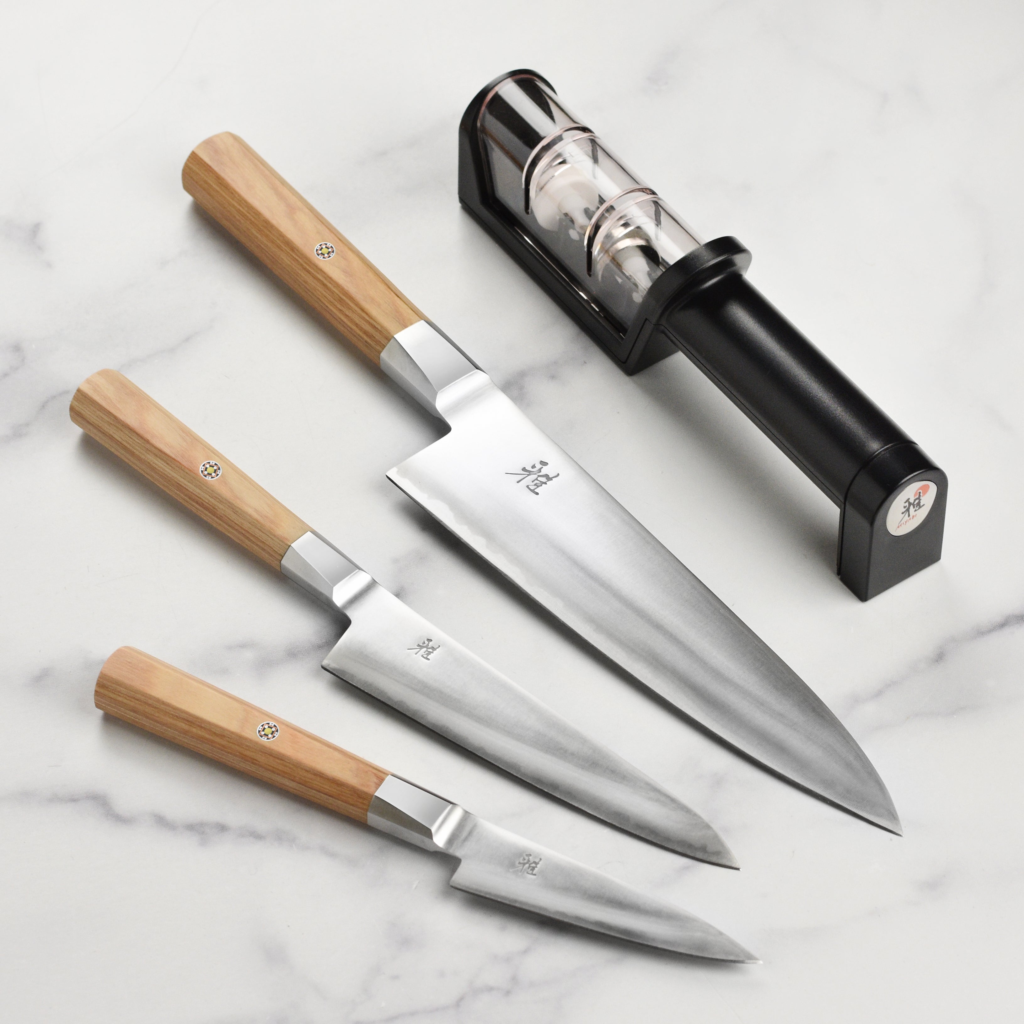 Miyabi Koya knife set with elegant birchwood handles, displayed on a wooden cutting board.