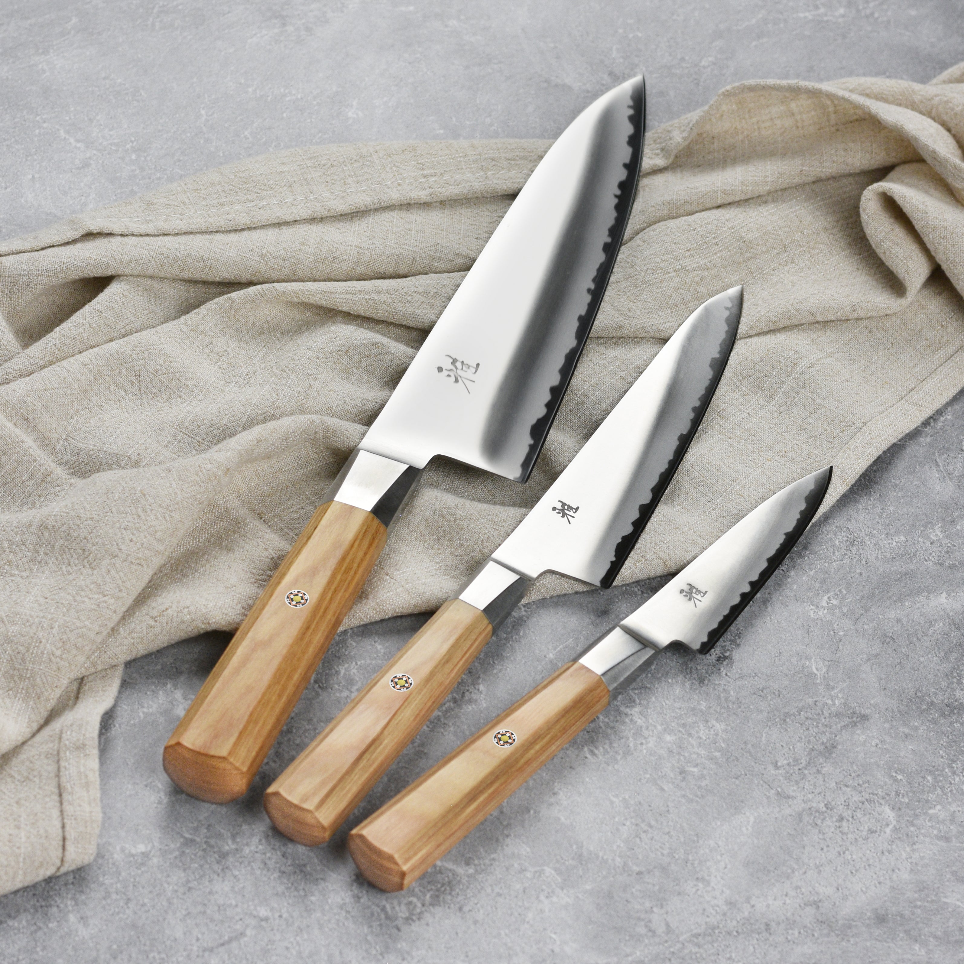 Styled shot of the magnetic knife set mounted on a sleek magnetic strip above a cutting board.