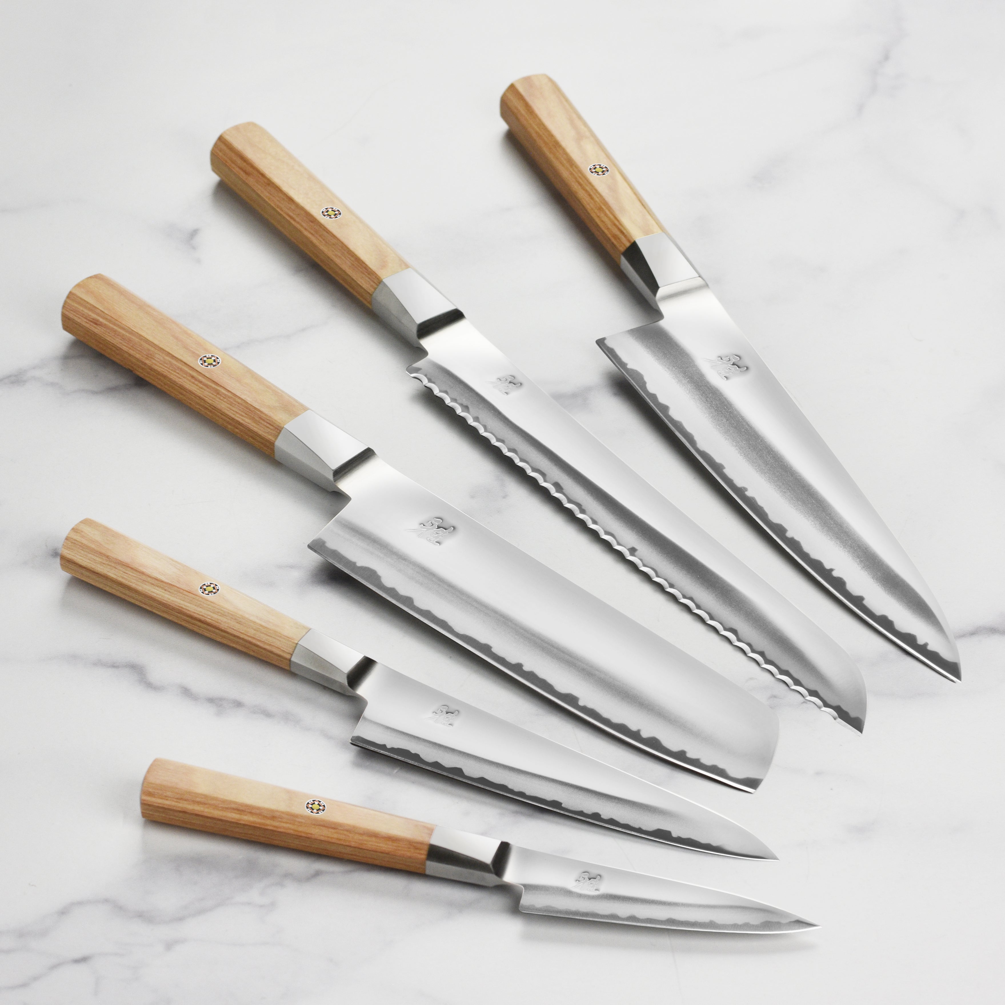 Styled shot of the magnetic knife set mounted on a sleek magnetic strip above a cutting board.