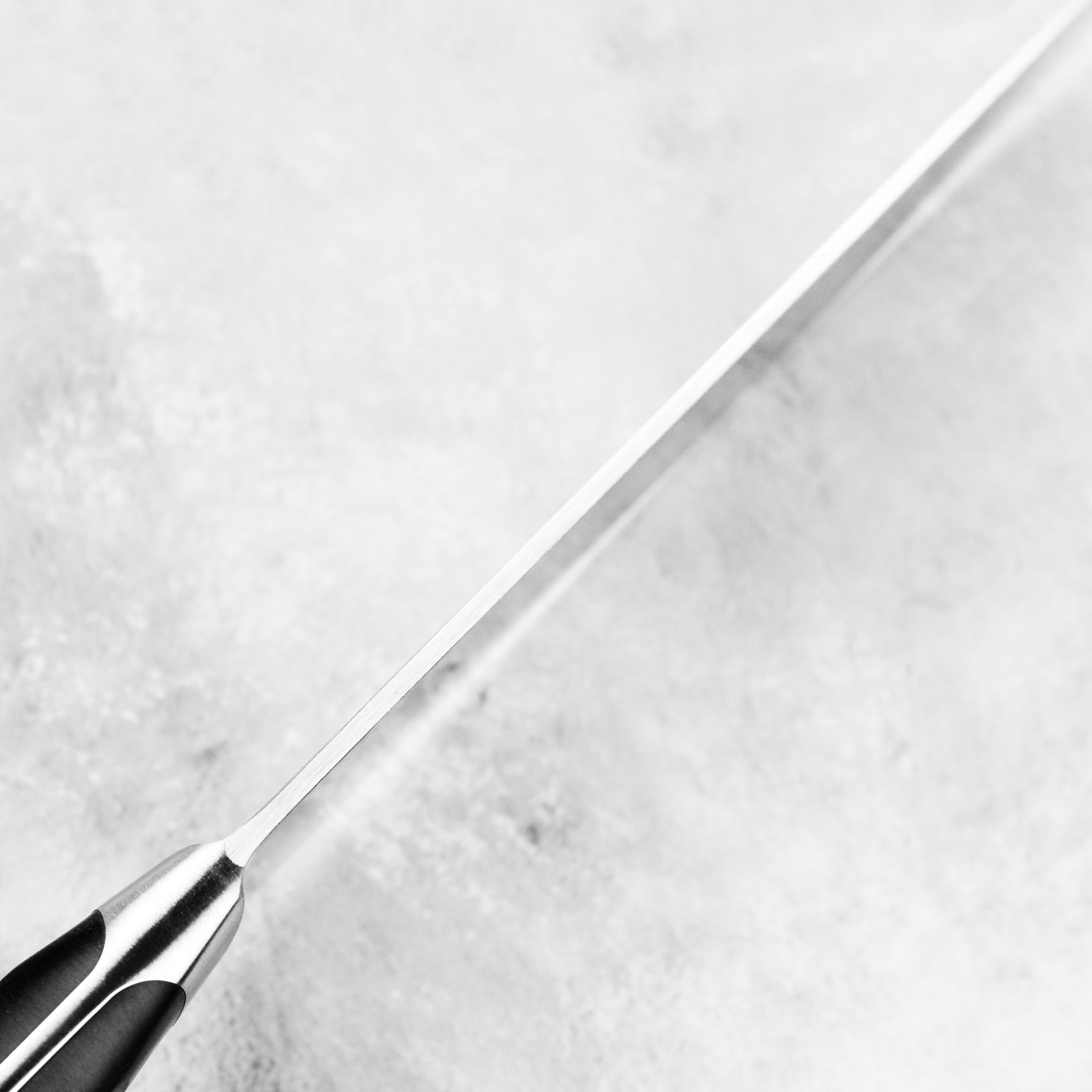 Close-up of Wusthof Classic chef knife with demi bolster, showing sharp blade and ergonomic handle