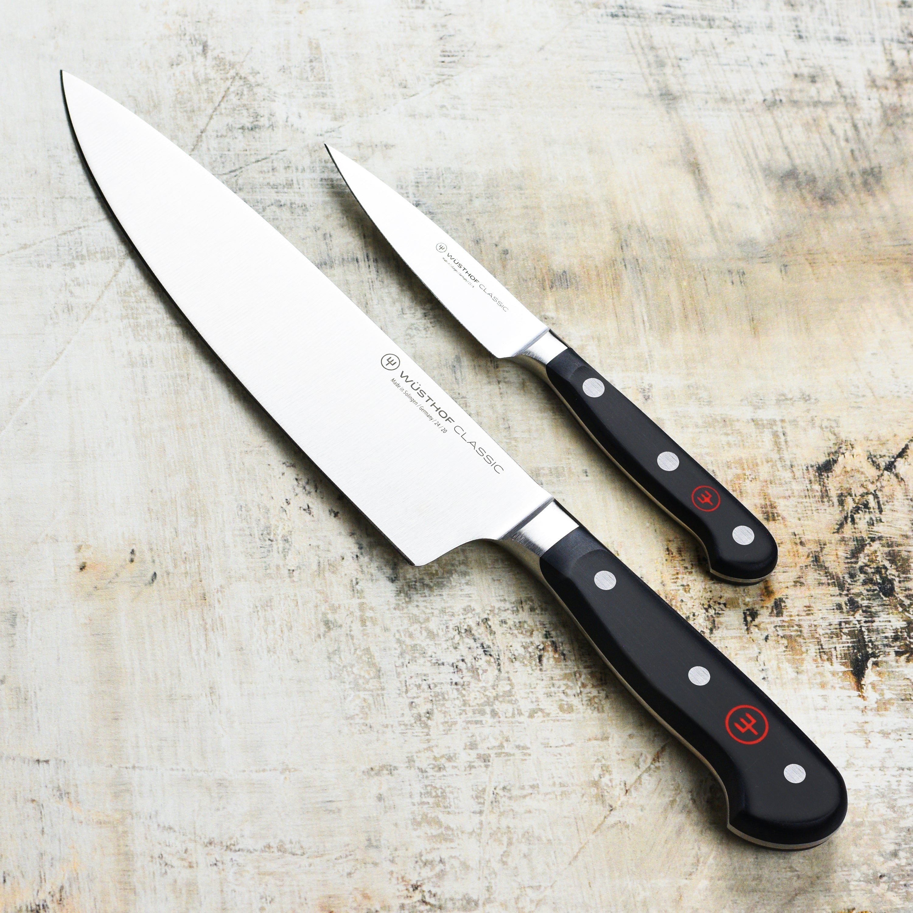 Wusthof knives with triple rivets and logo, resting on a wooden cutting board