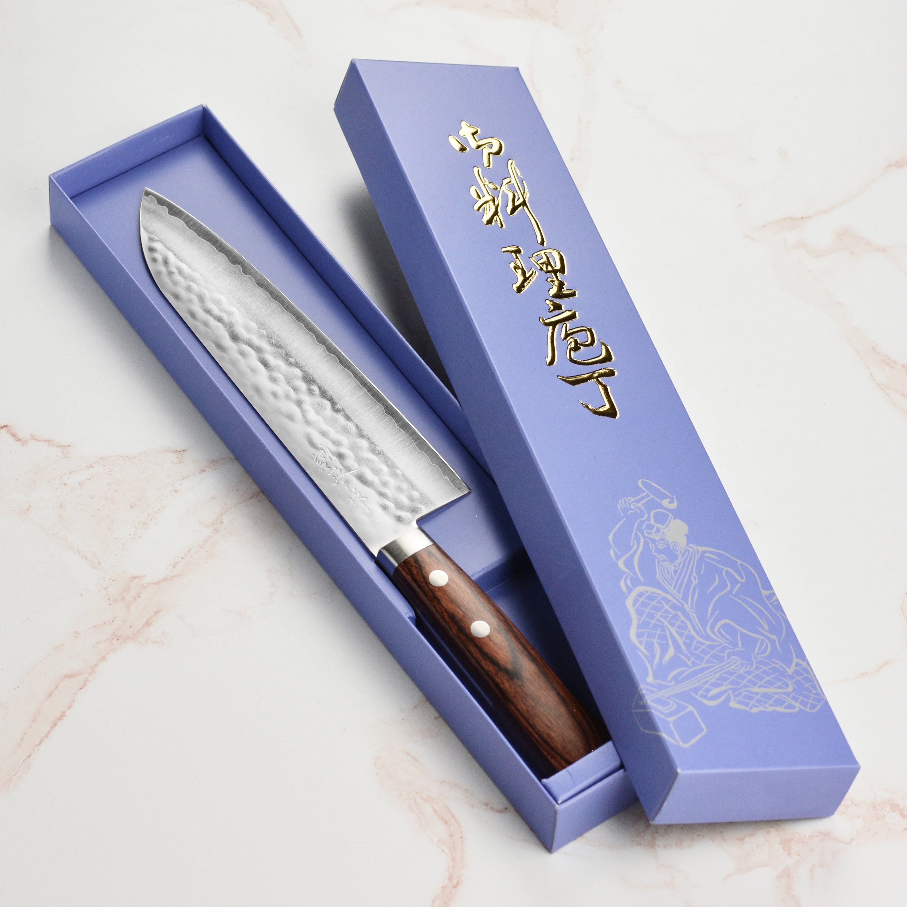 Close-up of the Masutani VG1 Gyuto knife showcasing the hammered finish and Pakkawood handle.