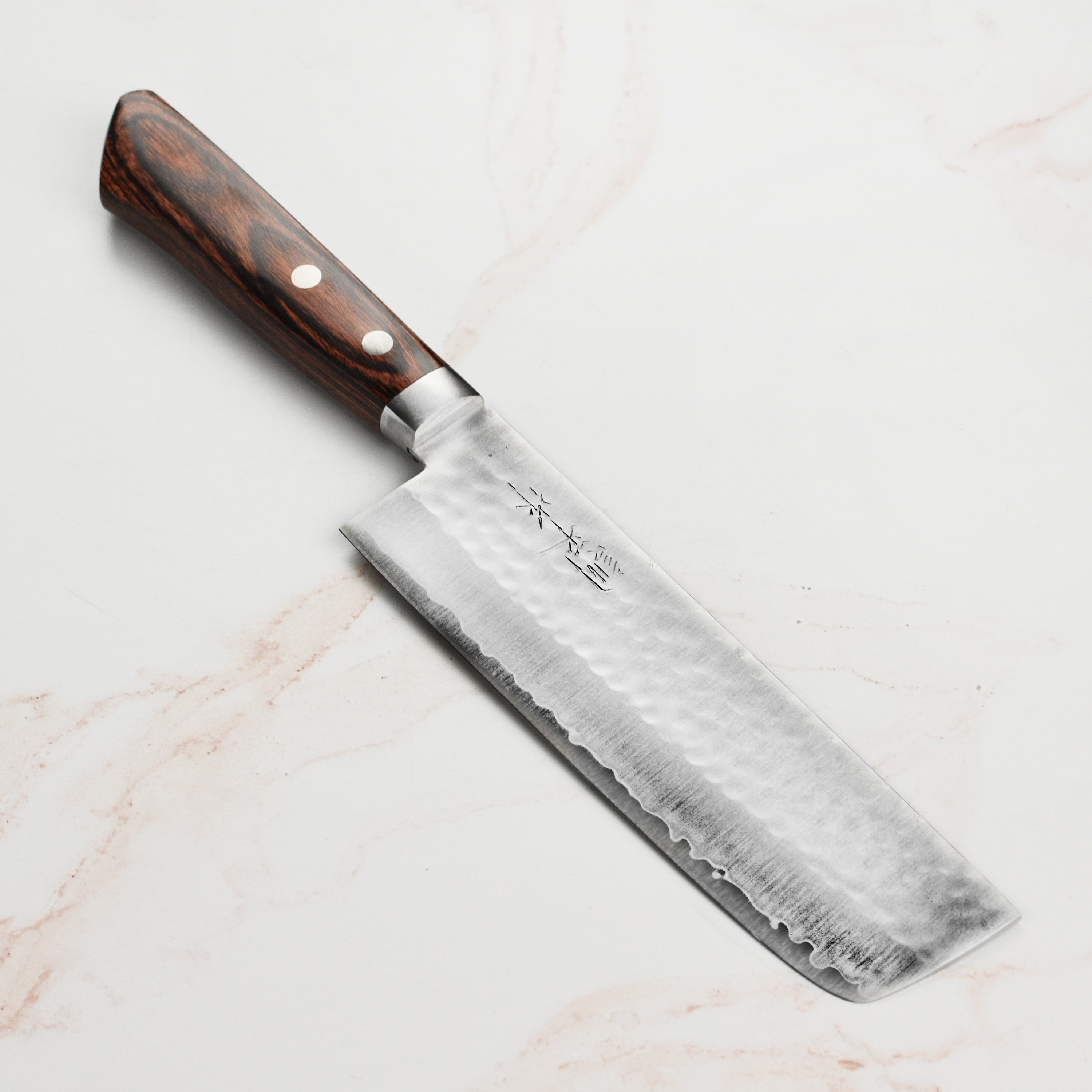 Masutani VG1 hammered Nakiri knife with Pakkawood handle on a cutting board