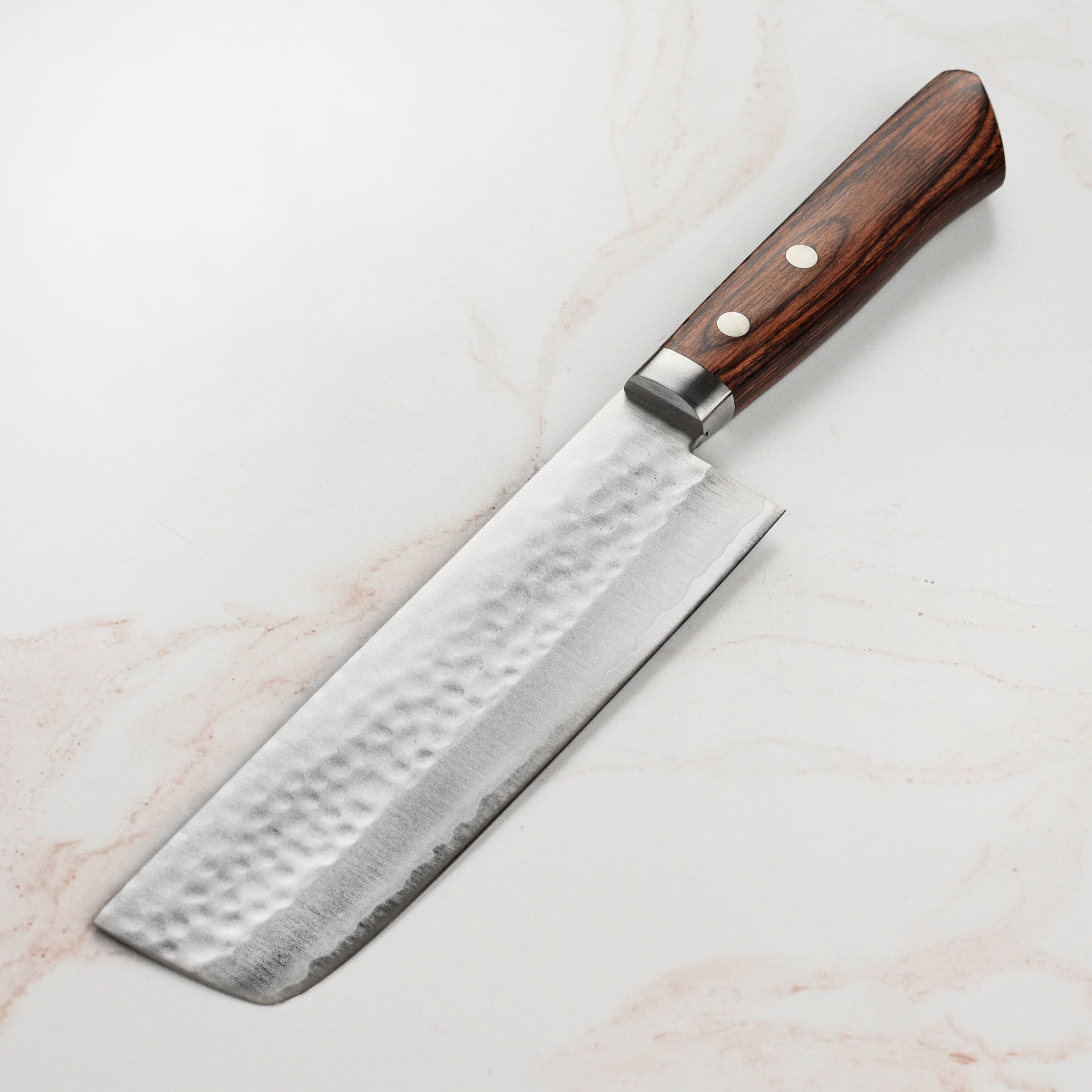 Chef slicing vegetables with the Masutani Nakiri knife, emphasizing its precision and quality