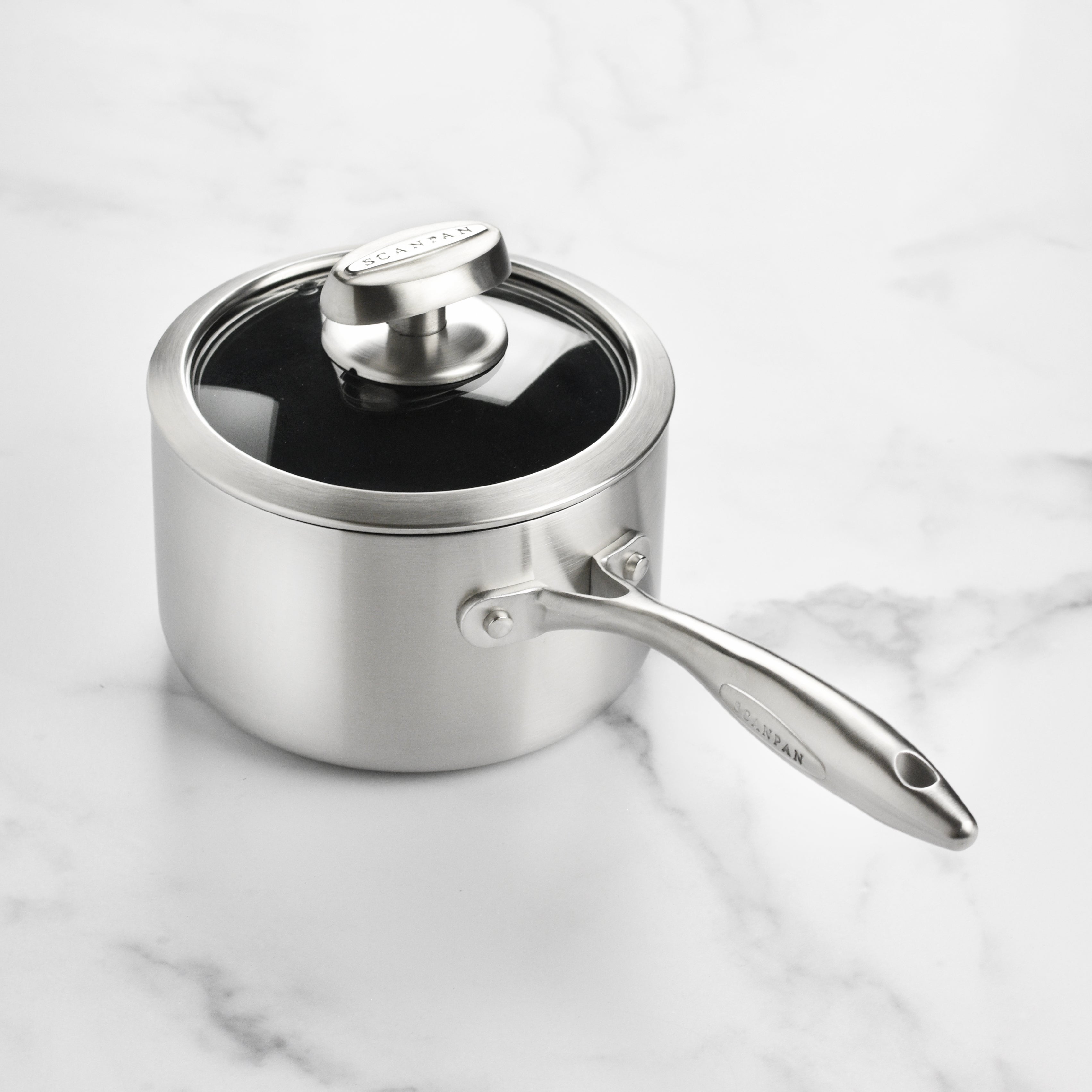 A chef using the Scanpan CX+ nonstick saucepan to prepare a sauce, showcasing its induction-ready capabilities.