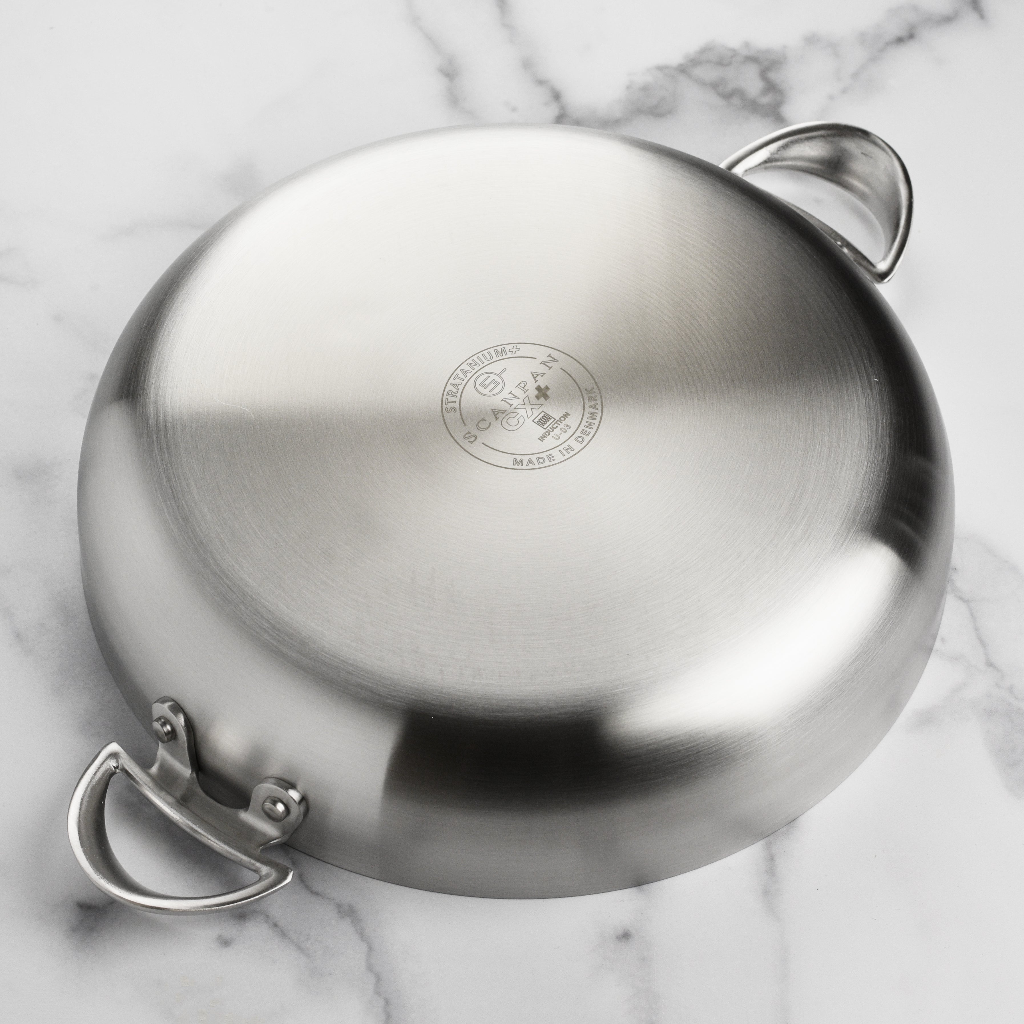 Close-up of the cast stainless steel handles demonstrating their cool-touch feature during cooking.