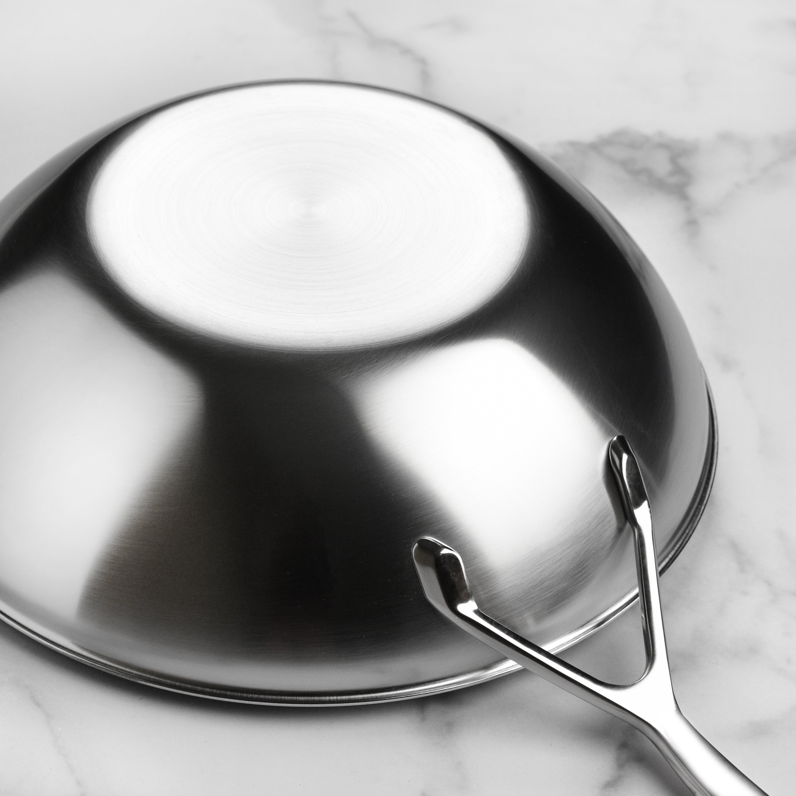 Close-up of the stainless steel flat bottom wok showing even construction