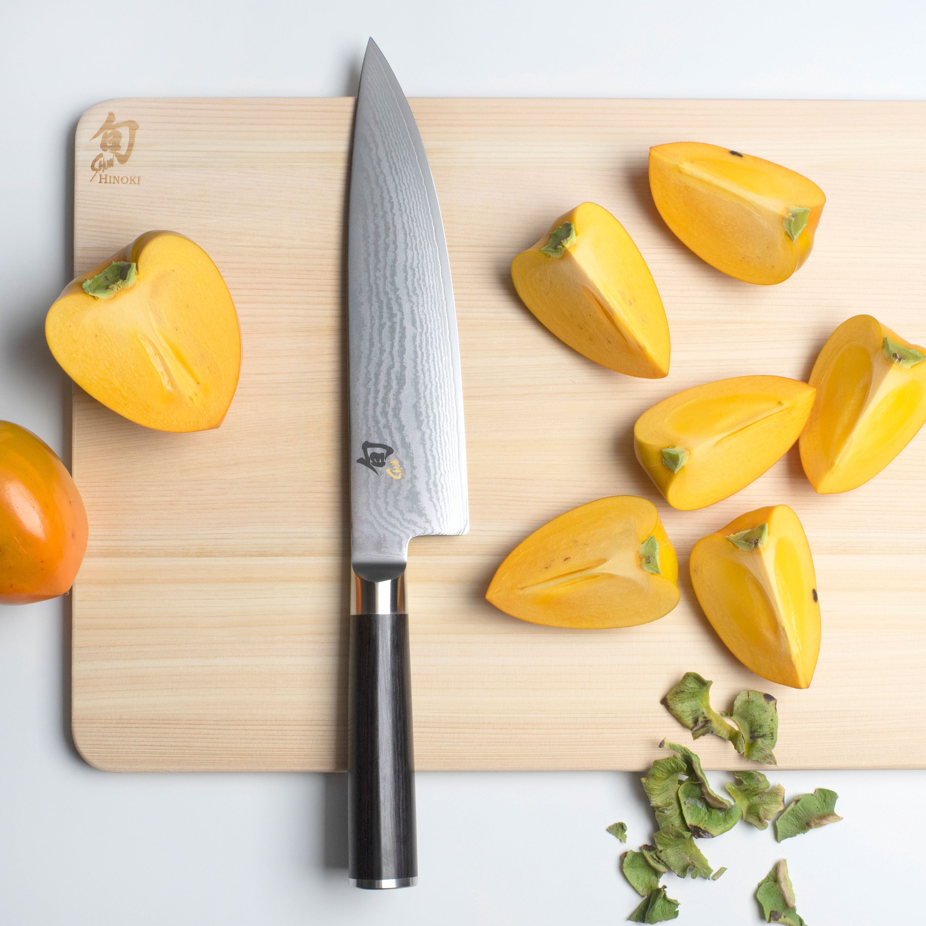 Chef using Shun Classic knife for precise slicing in a modern kitchen