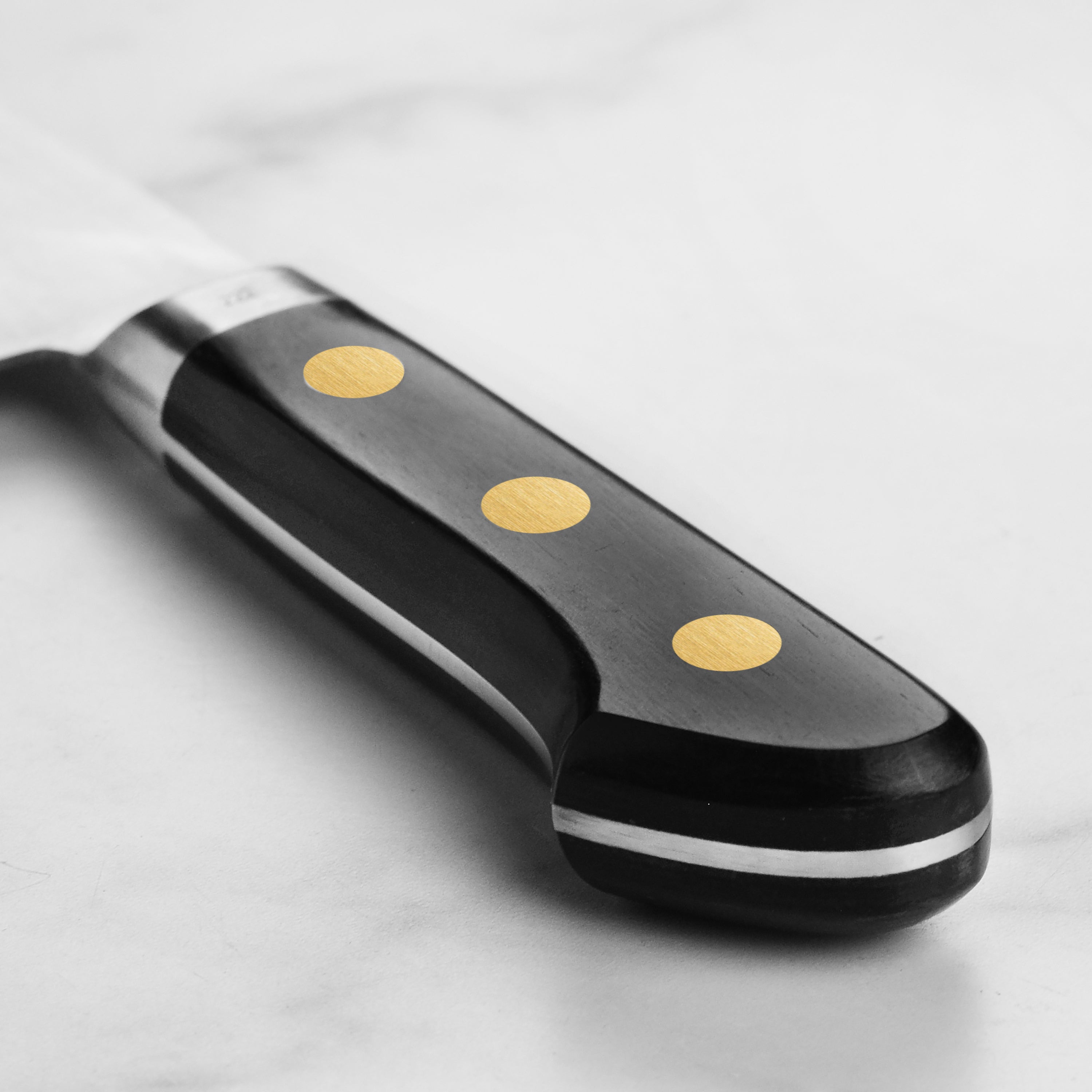 Japanese chef knife with Pakkawood handle and brass rivets in a kitchen setting