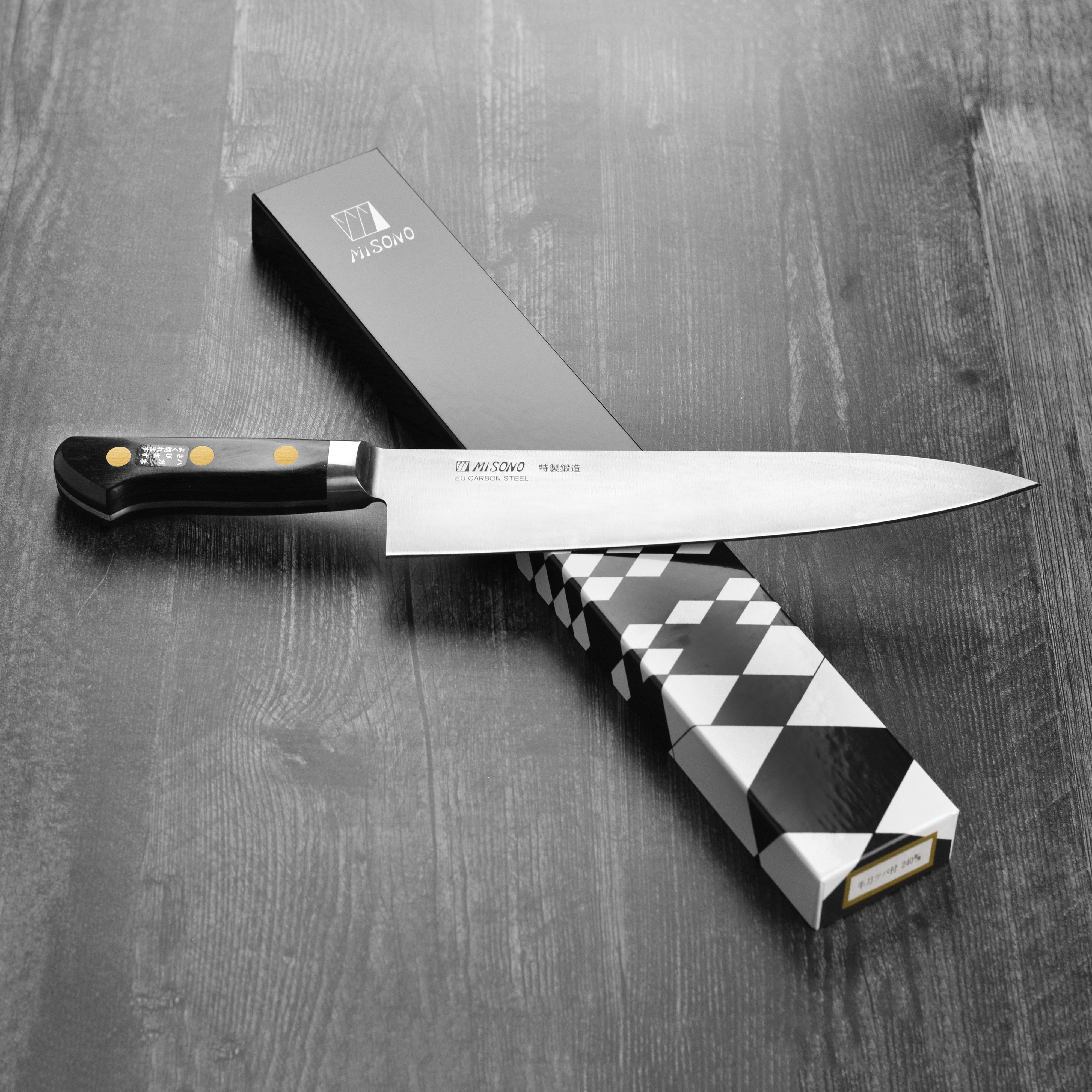 Japanese chef knife with Pakkawood handle and brass rivets in a kitchen setting