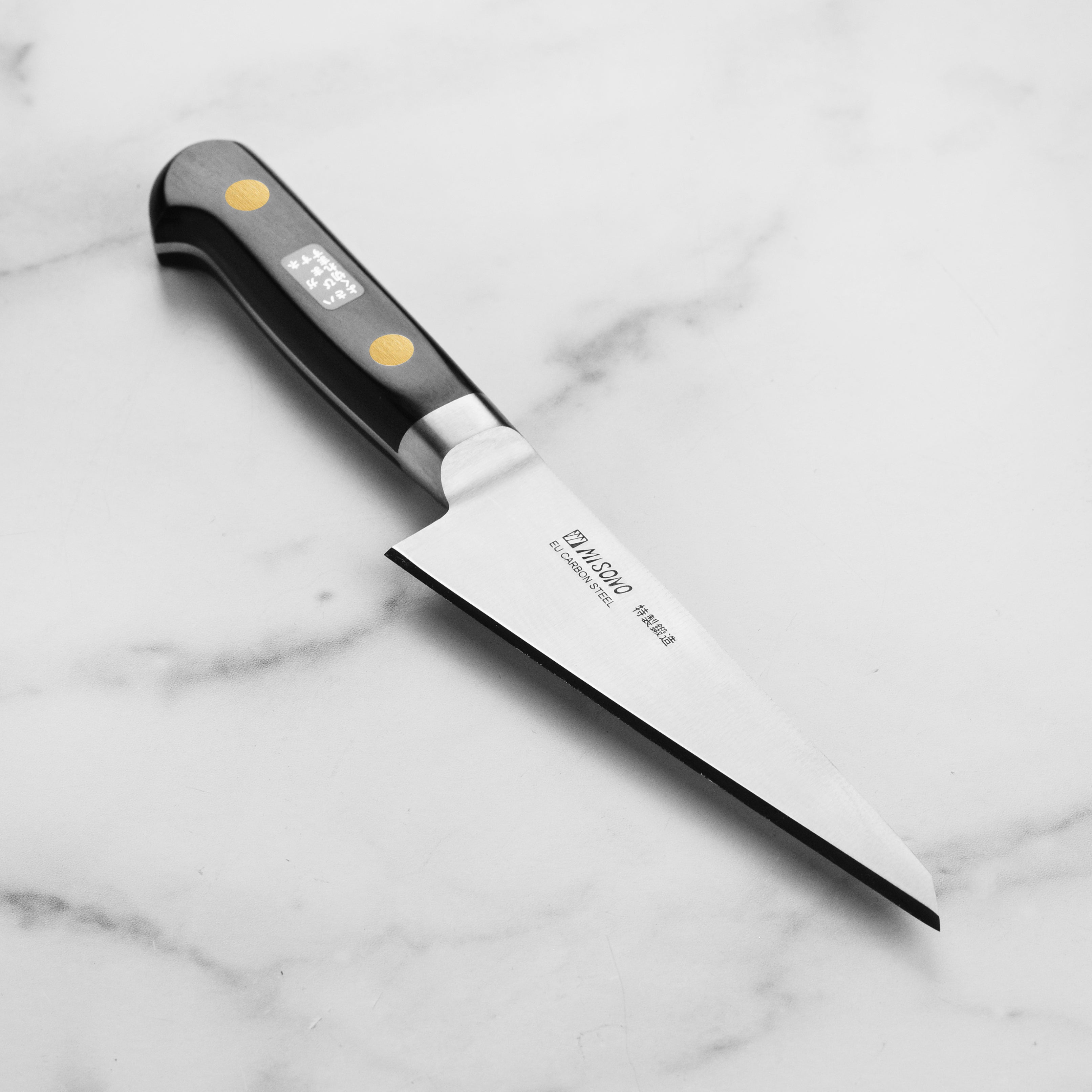Misono Honesuki carbon steel knife showcasing its sharp blade and elegant handle for poultry preparation.