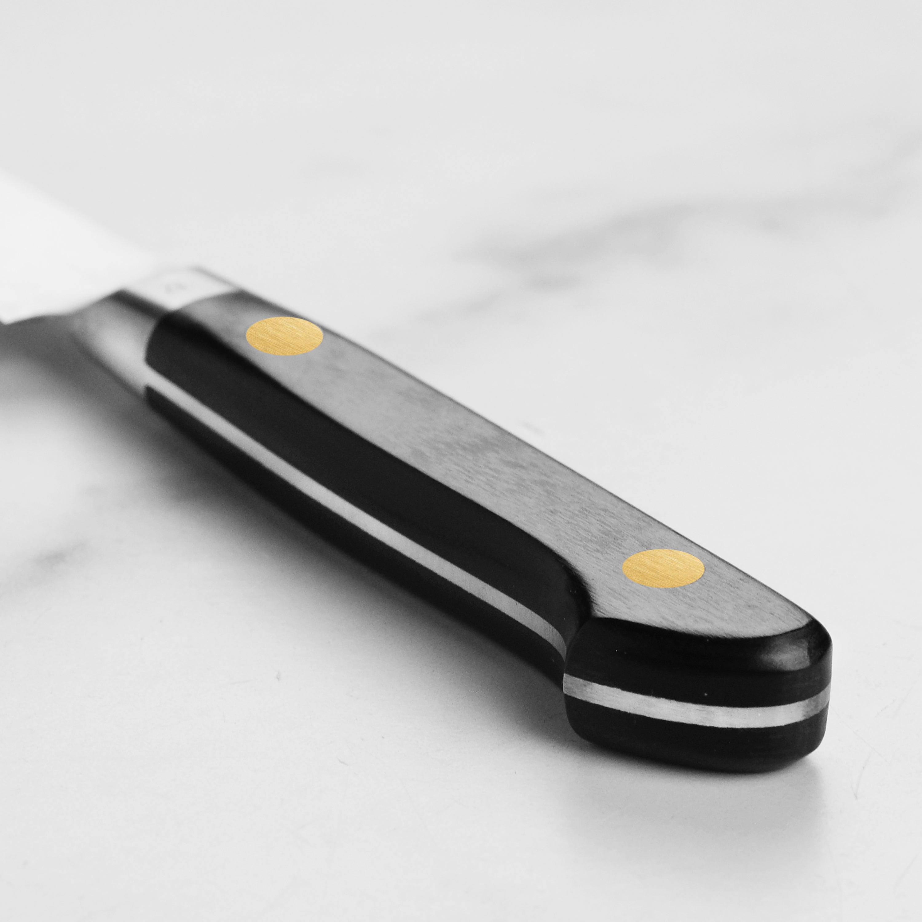 Close-up view of the hand-forged blade of the Misono petty knife highlighting its sharpness and craftsmanship.