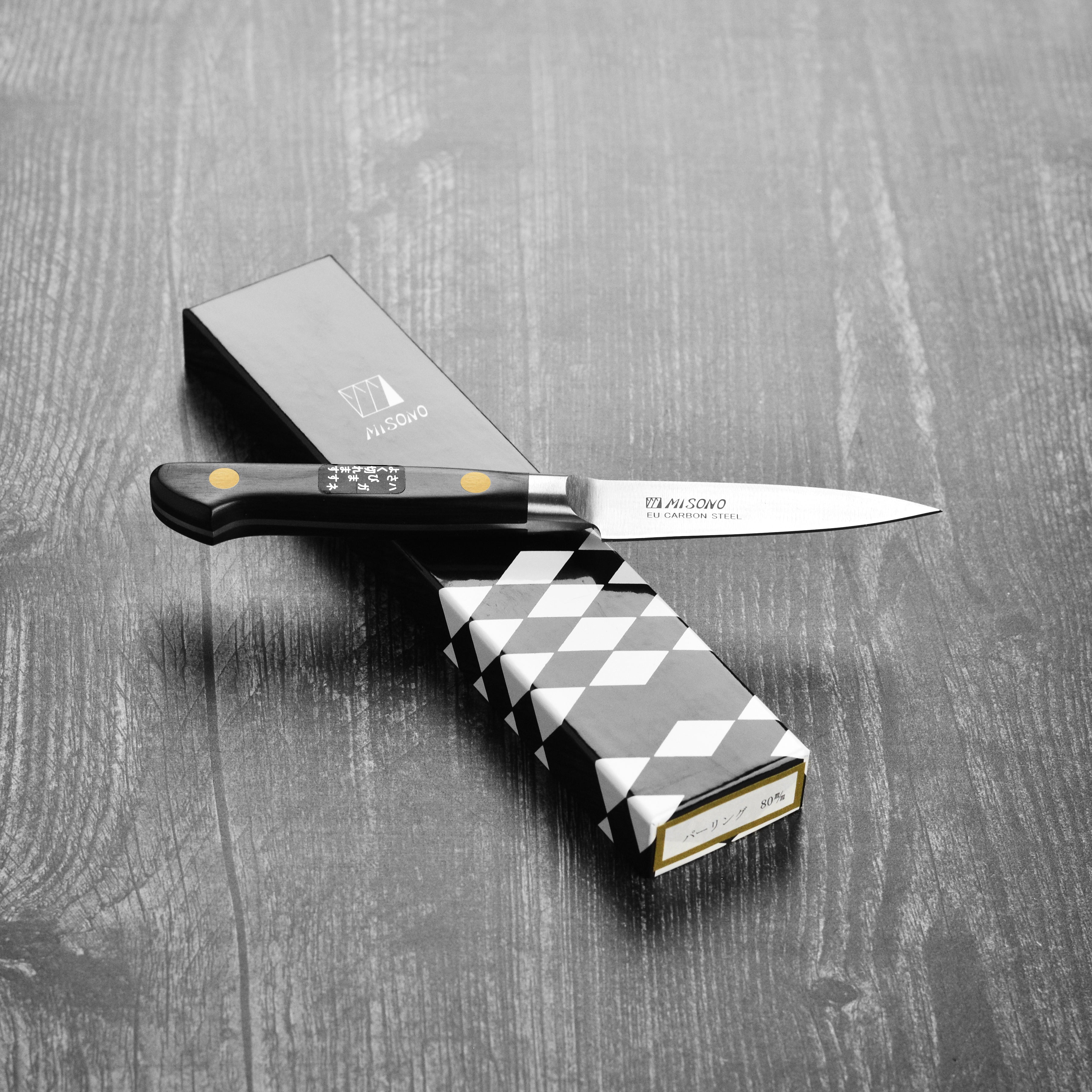 Misono Swedish carbon steel petty knife displayed on a cutting board, ready for culinary tasks.