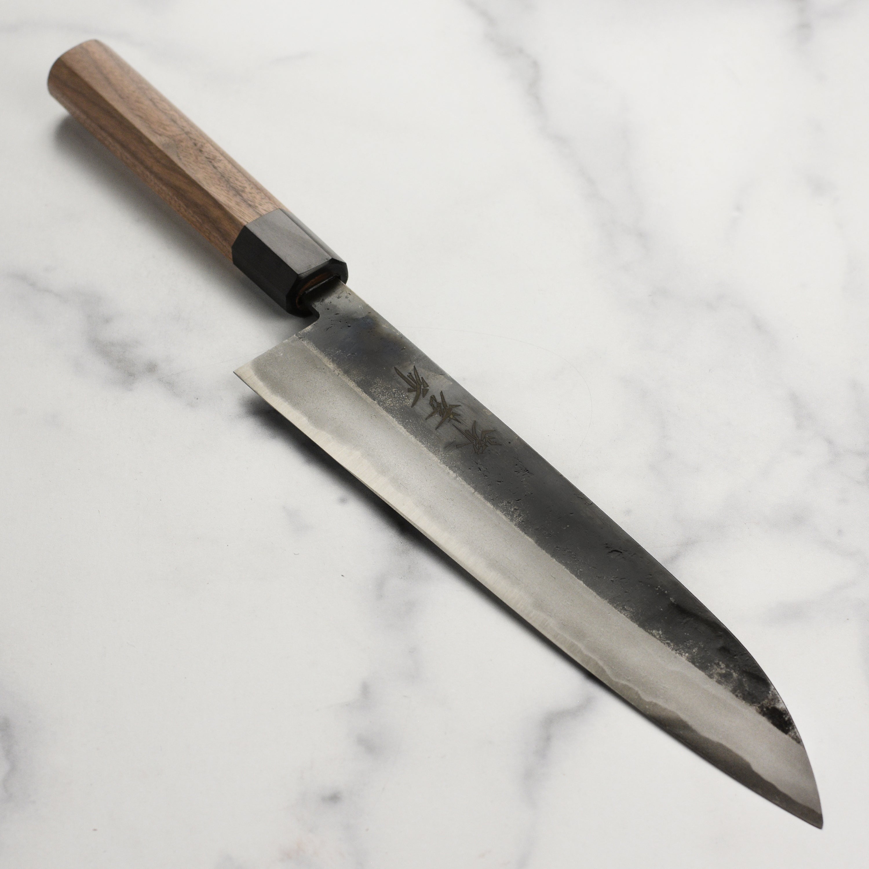 Side profile of the Takayuki Kurouchi Aogami chef knife showing carbon steel blade and wooden handle