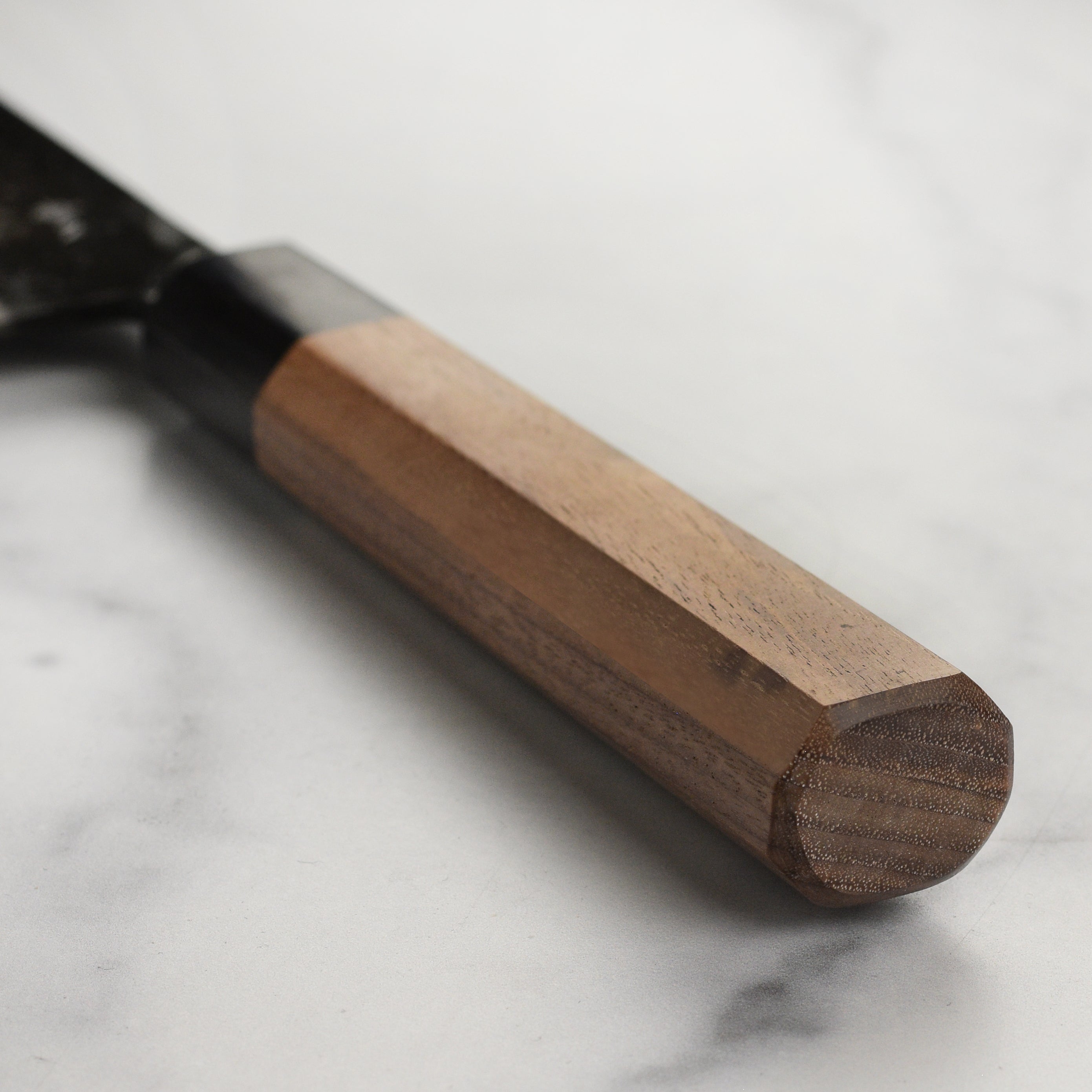 Close-up of double bevel edge of the handmade Japanese knife ready for slicing meats or vegetables