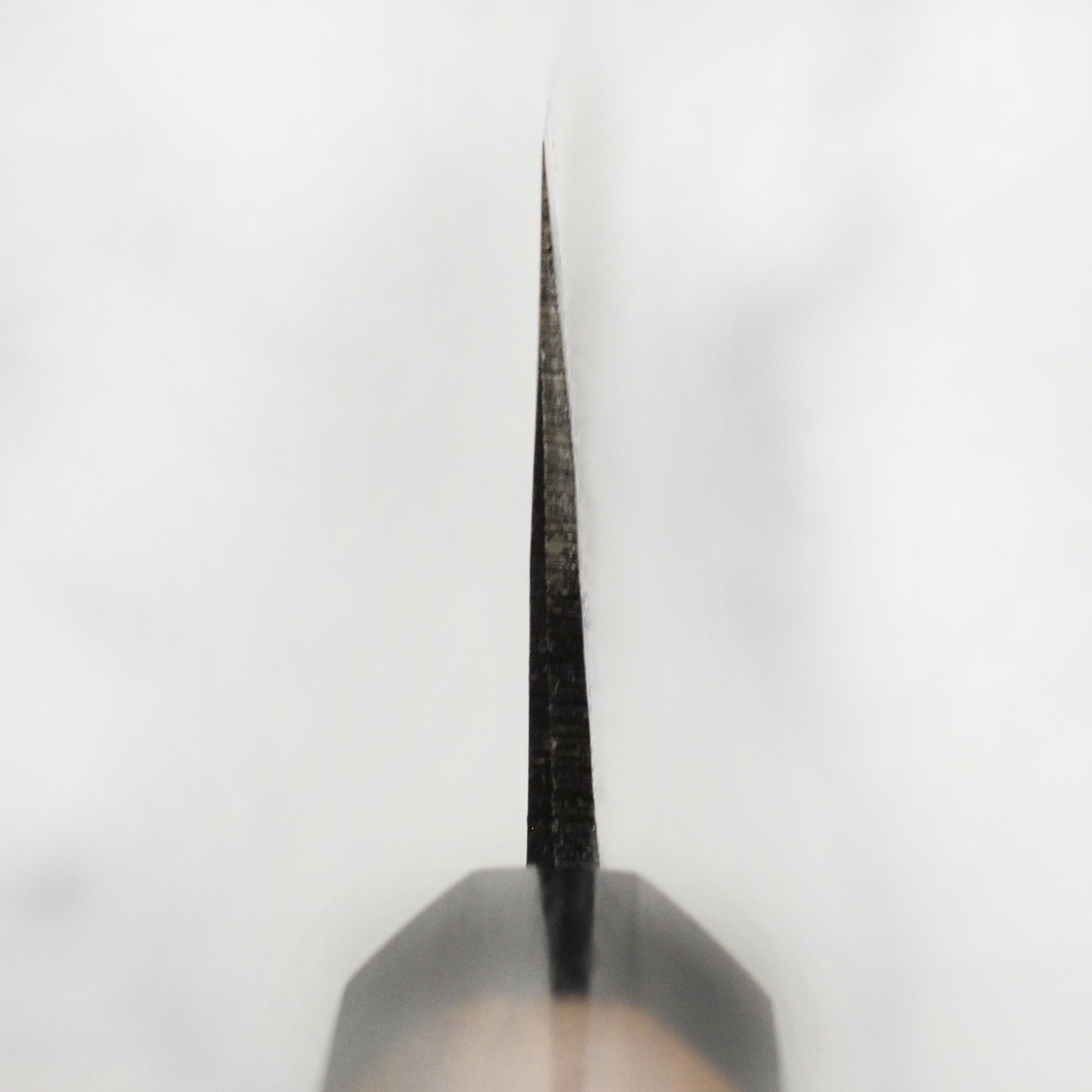 Close-up of double bevel edge of the handmade Japanese knife ready for slicing meats or vegetables