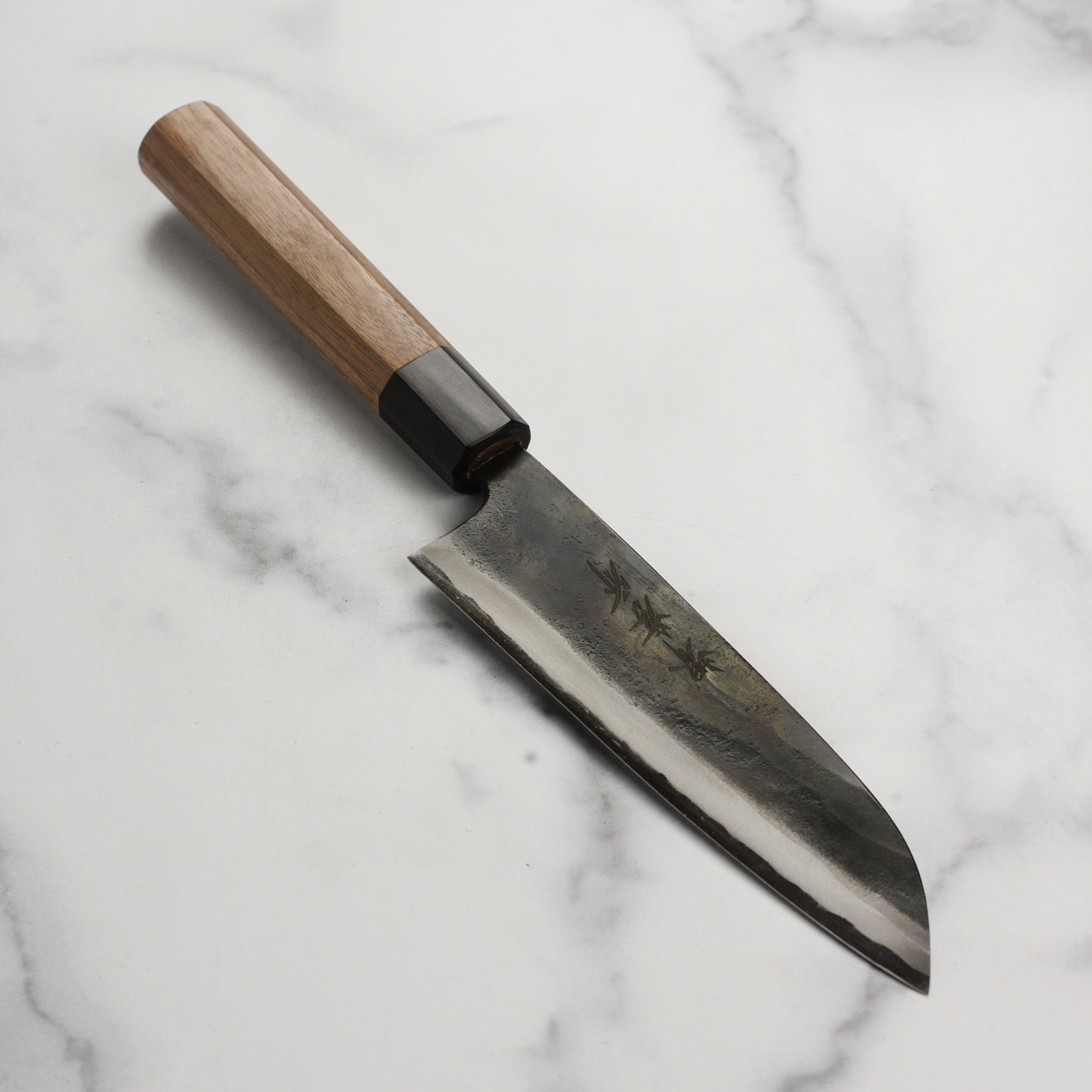Close-up of the Aogami Kurouchi 6.7-inch Santoku knife blade showing kurouchi finish