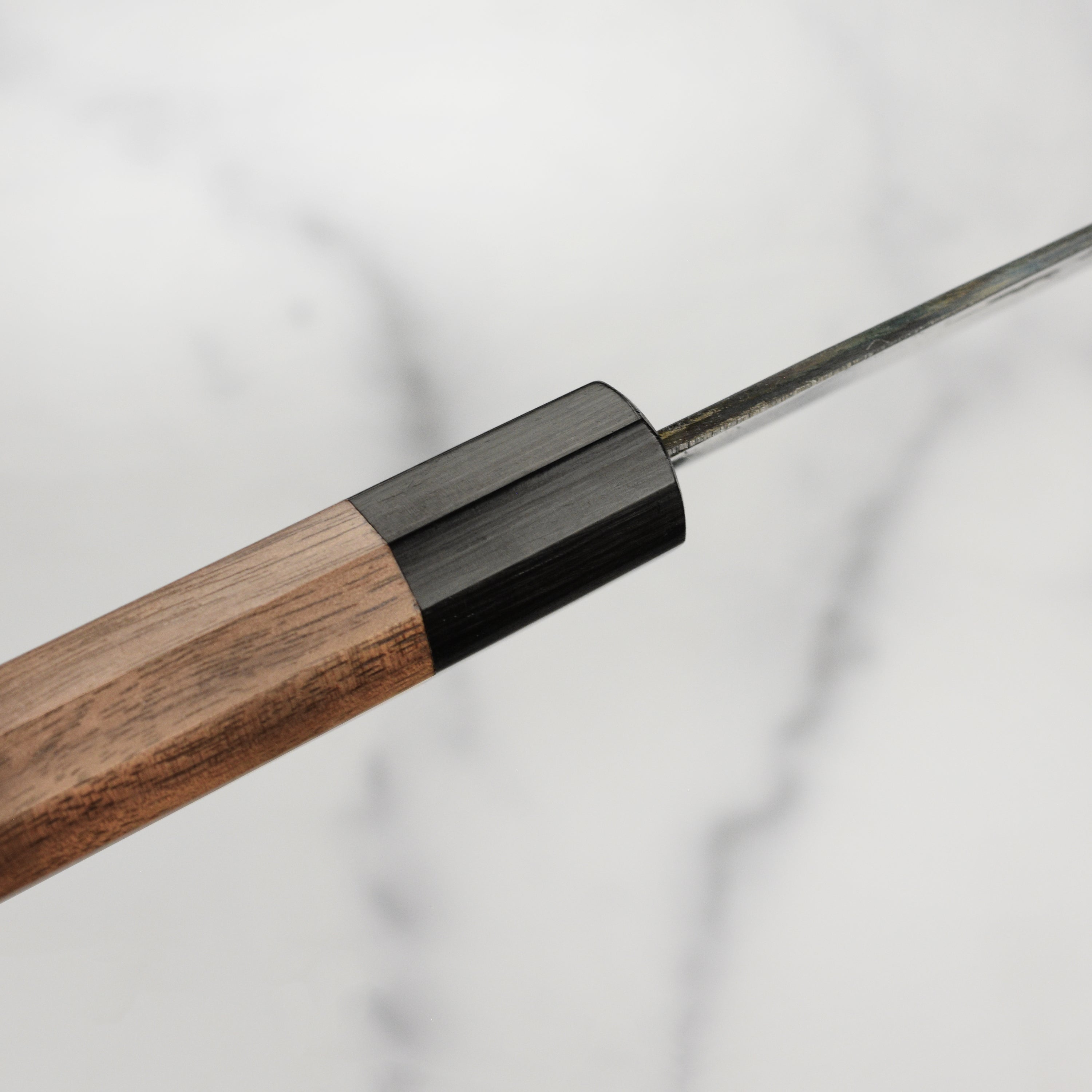 Handcrafted Japanese chef knife with walnut handle in a professional kitchen setting