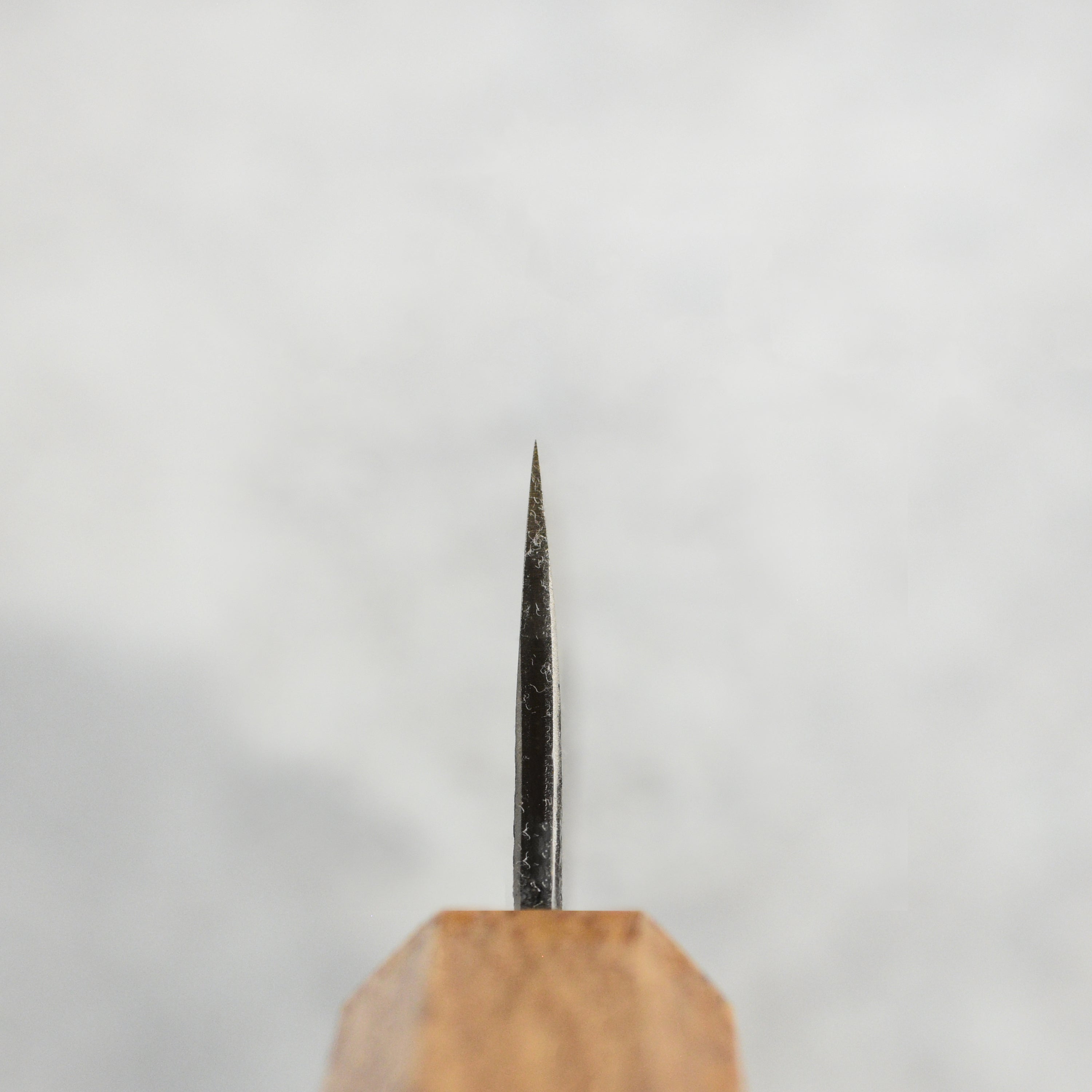 The ergonomic burnt oak handle of the Japanese chef knife, designed for comfort.