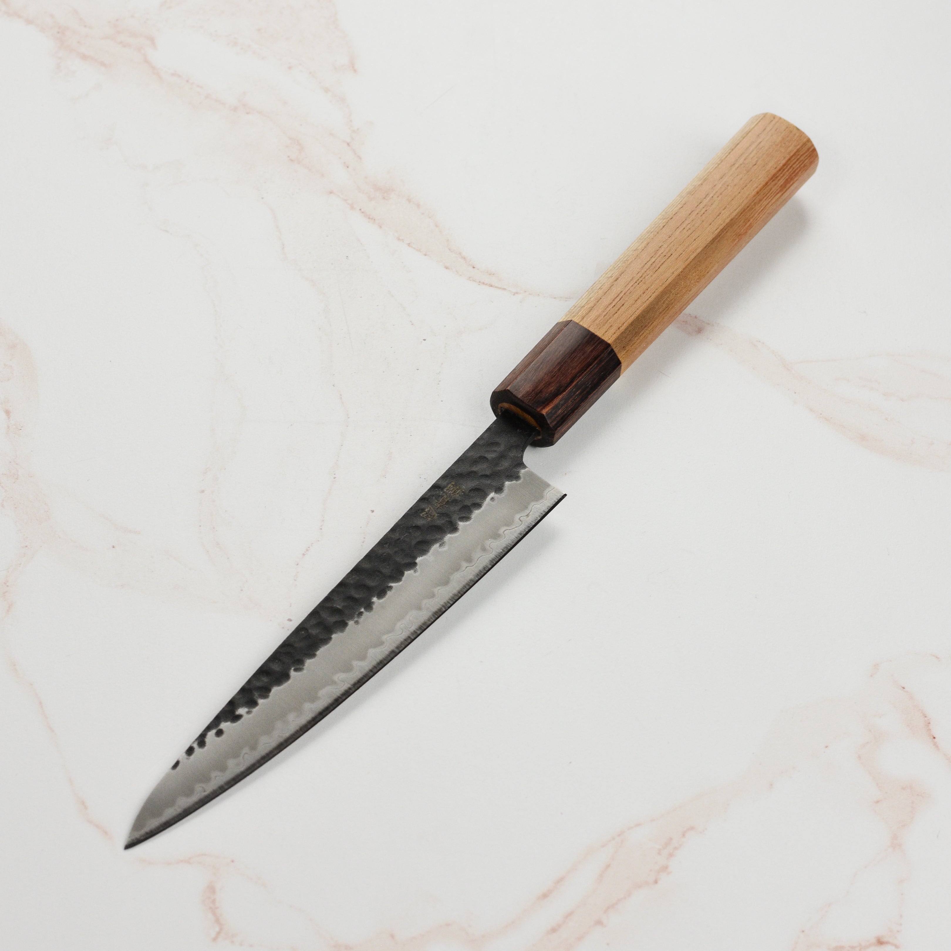 Takayuki petty knife in use, chopping vegetables on a wooden cutting board