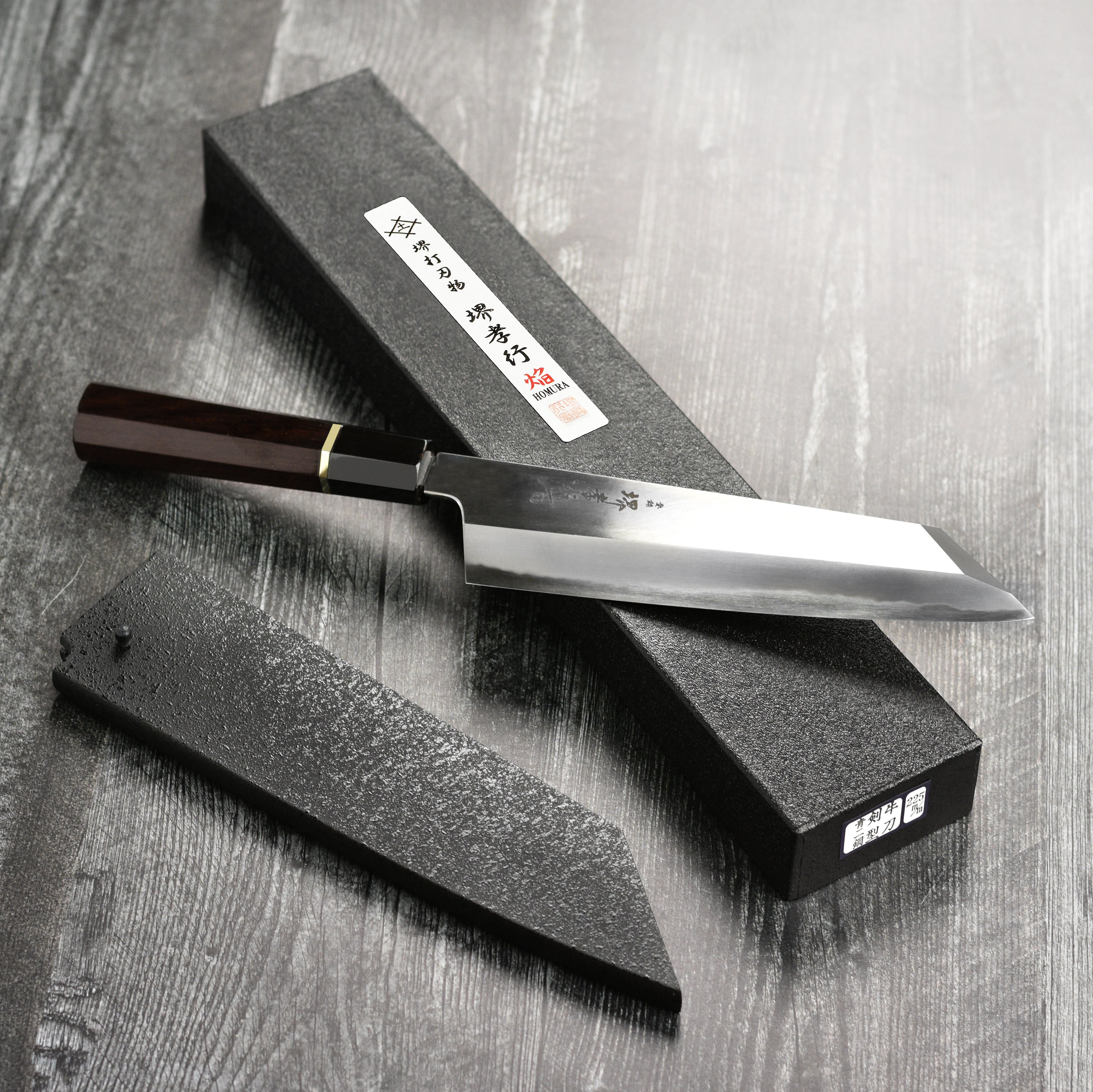 Display of the Sakai Master Gyuto knife alongside fresh vegetables, illustrating its use in a kitchen setting.
