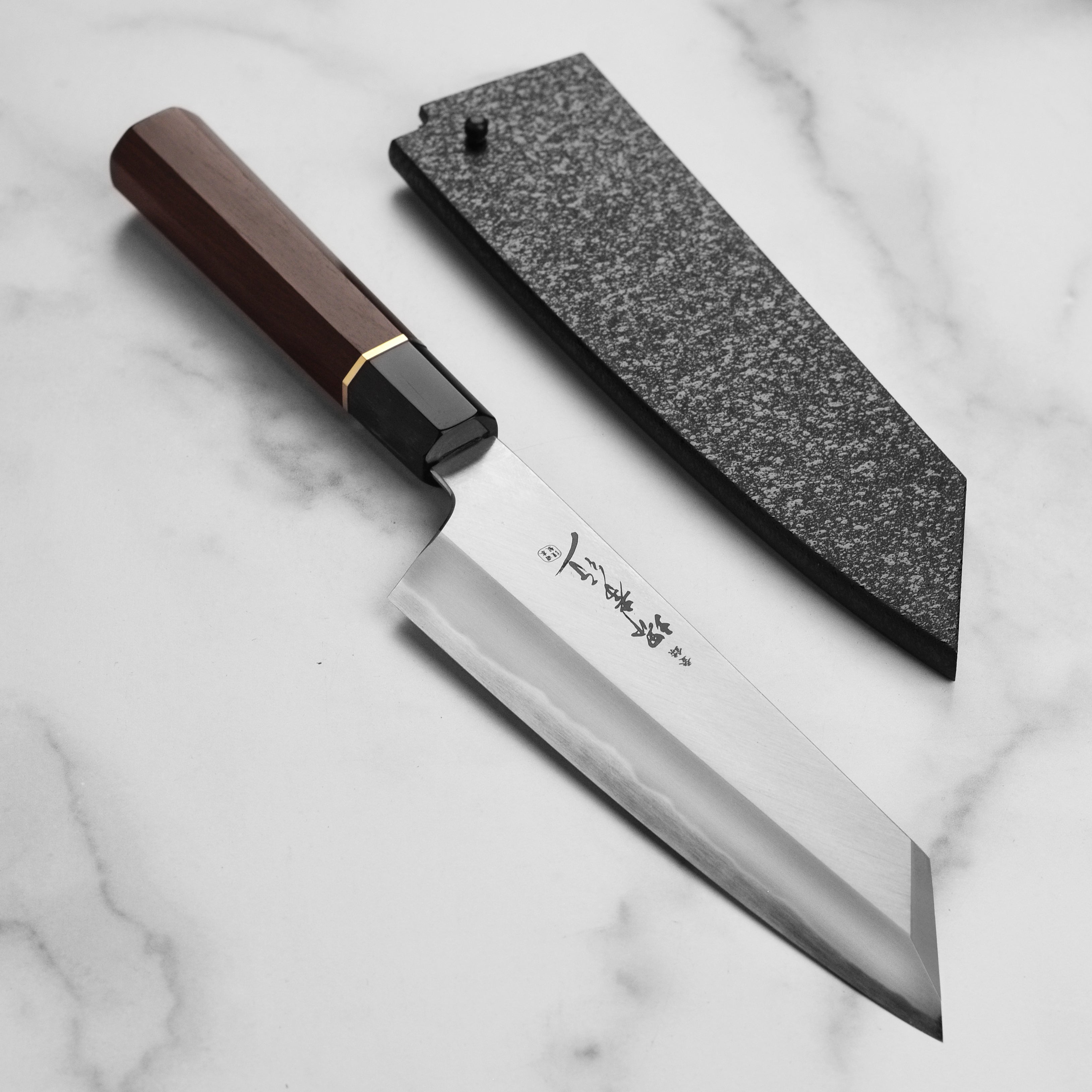 Close-up of Takayuki Homura Kengata Gyuto knife showcasing the sharp blade and elegant handle.