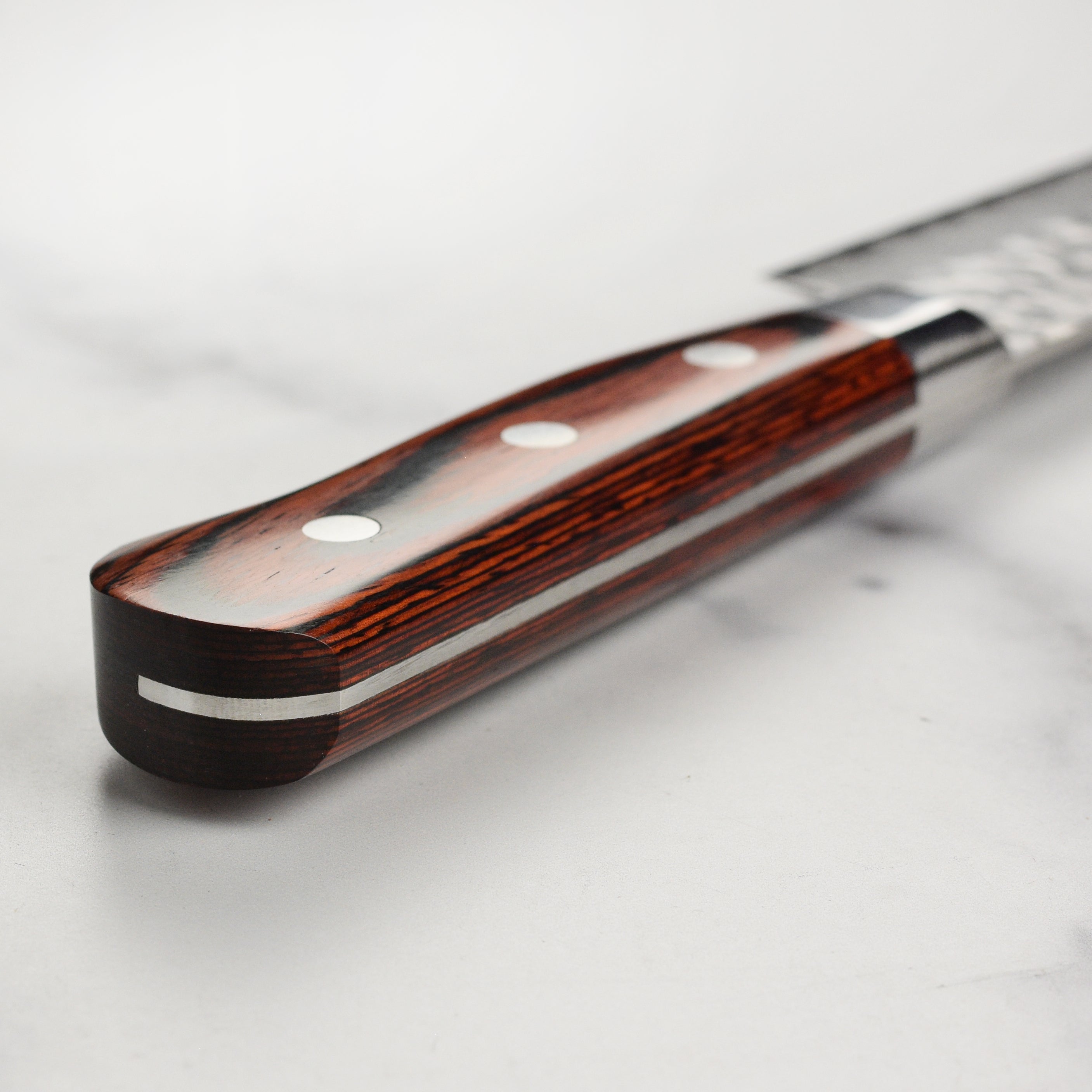 Close-up of the Sakai Mastercraft Damascus petty knife blade highlighting its craftsmanship and 33-layer design.
