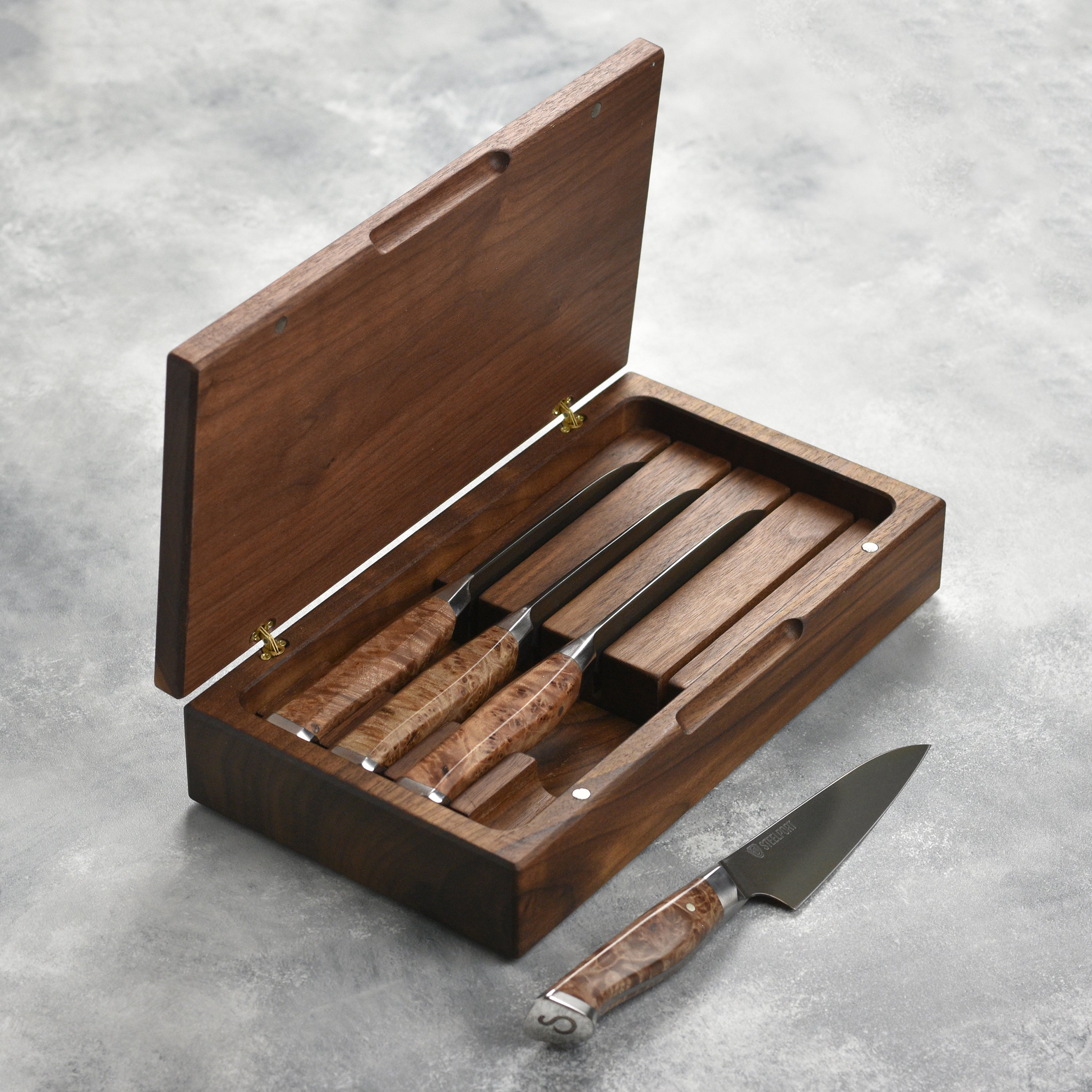 Steelport steak knife set with case displayed on a kitchen counter.