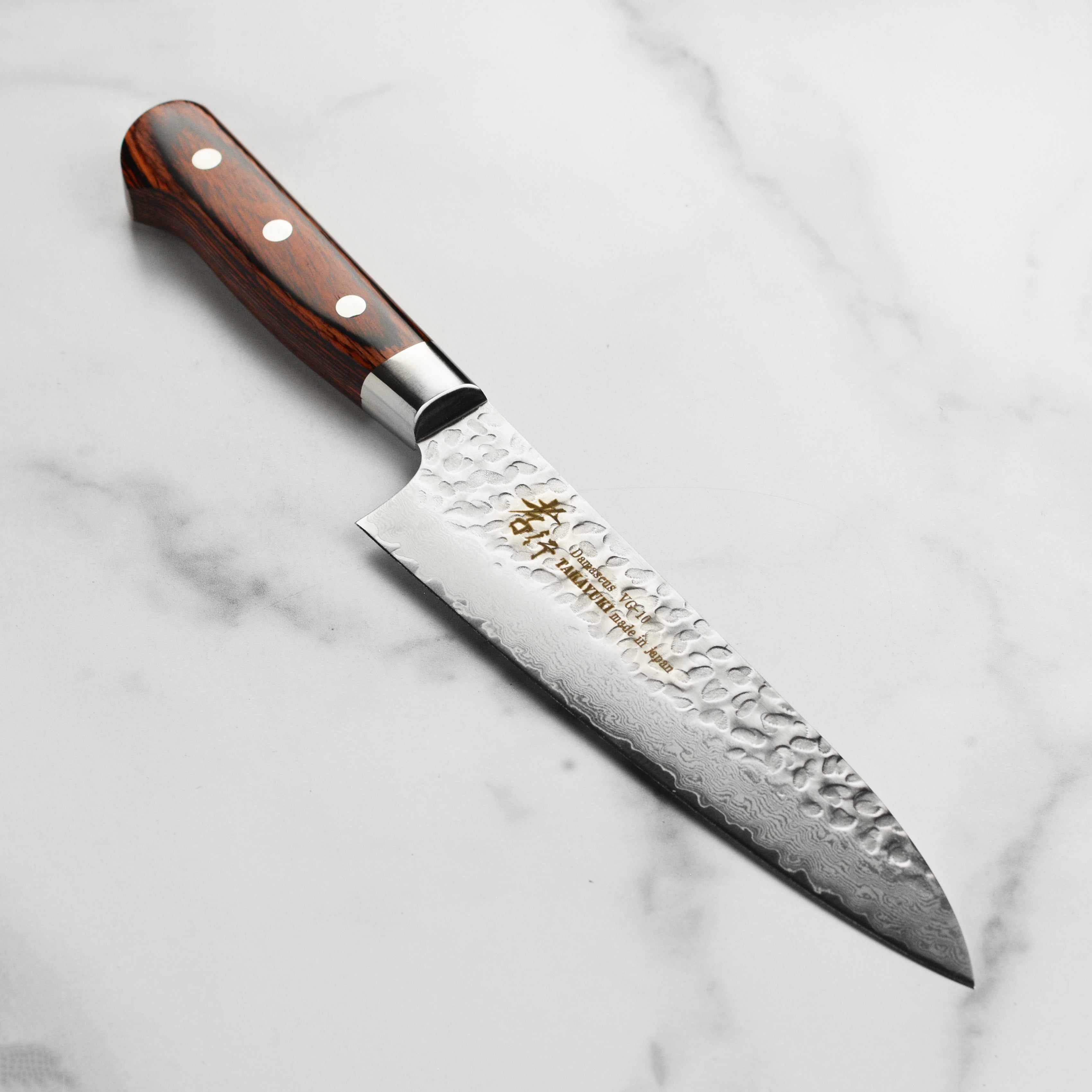 Close-up of the Sakai Master Hammered Damascus Gyuto Chef Knife blade highlighting the 33-layer structure.