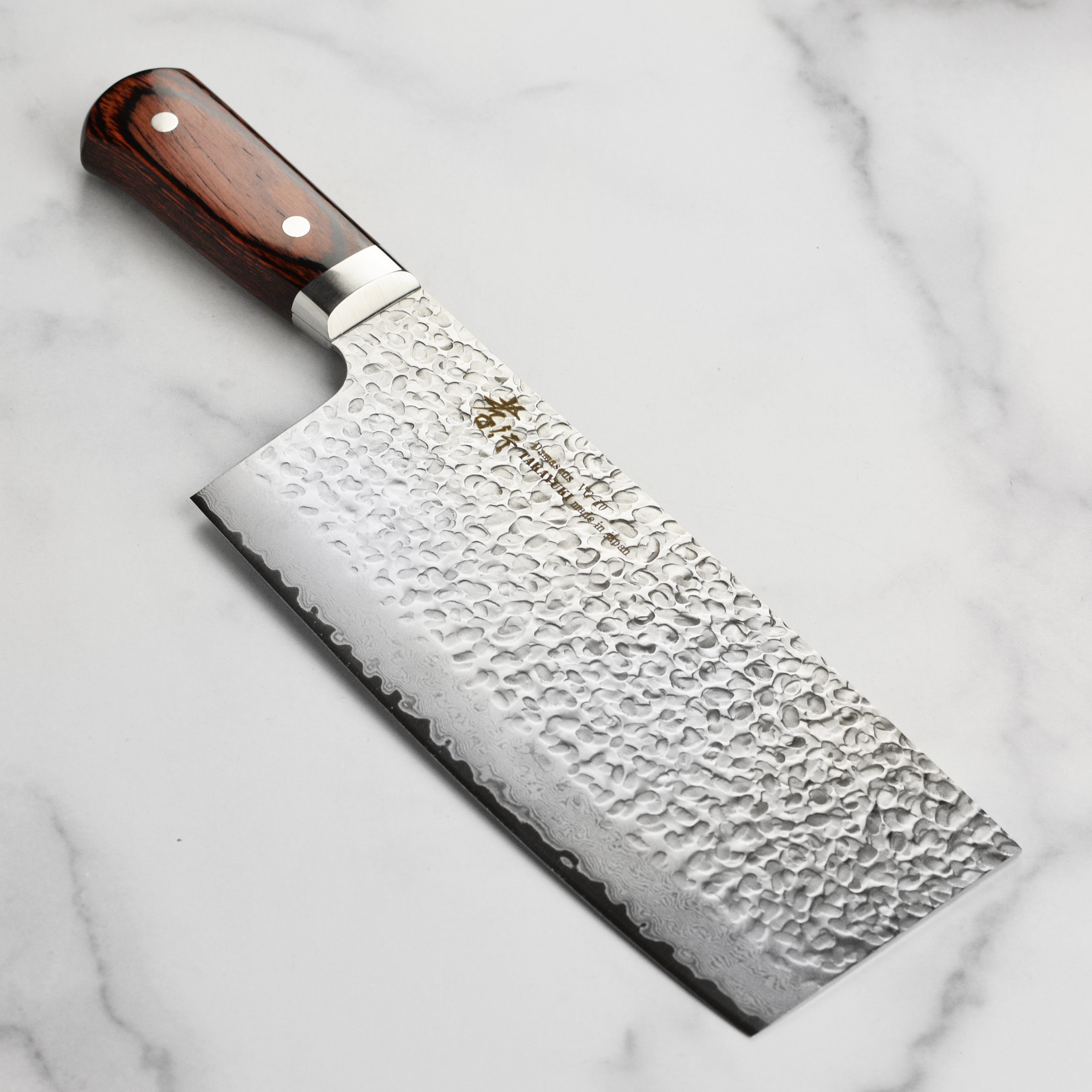 Sakai Hammered Damascus Chef's Knife showcasing the stunning blade design from the side.
