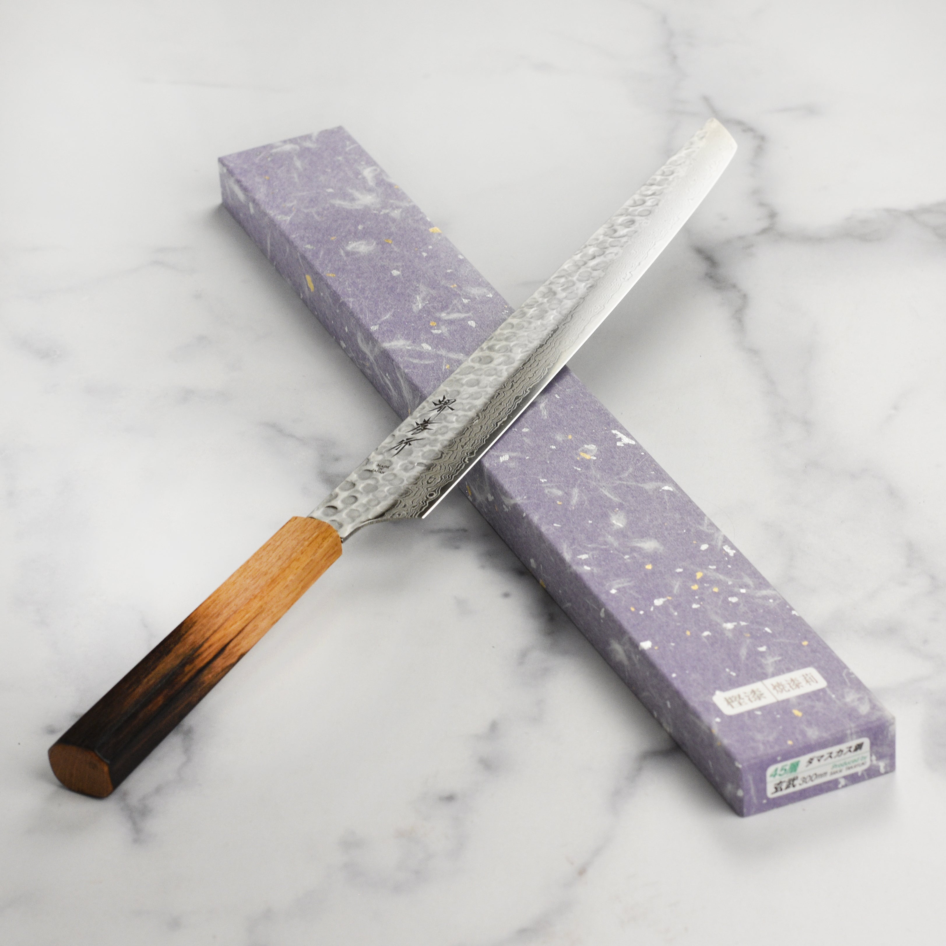 The octagonal burnt oak handle of the Sakimaru-Yanagiba knife, emphasizing its ergonomic design.
