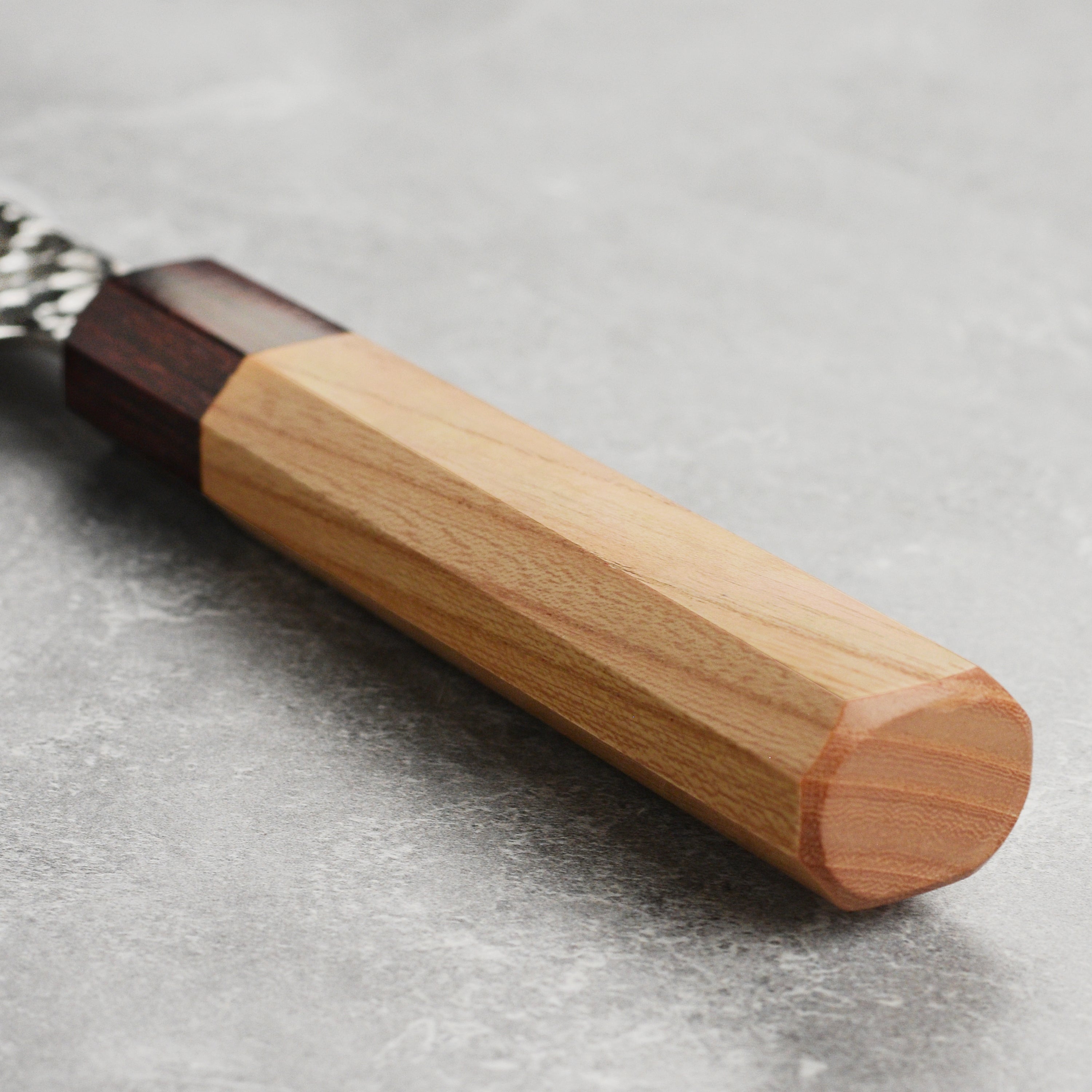 Octagonal Zelkova wood handle of the Japanese kitchen knife, showing the smooth finish and mahogany ferrule.