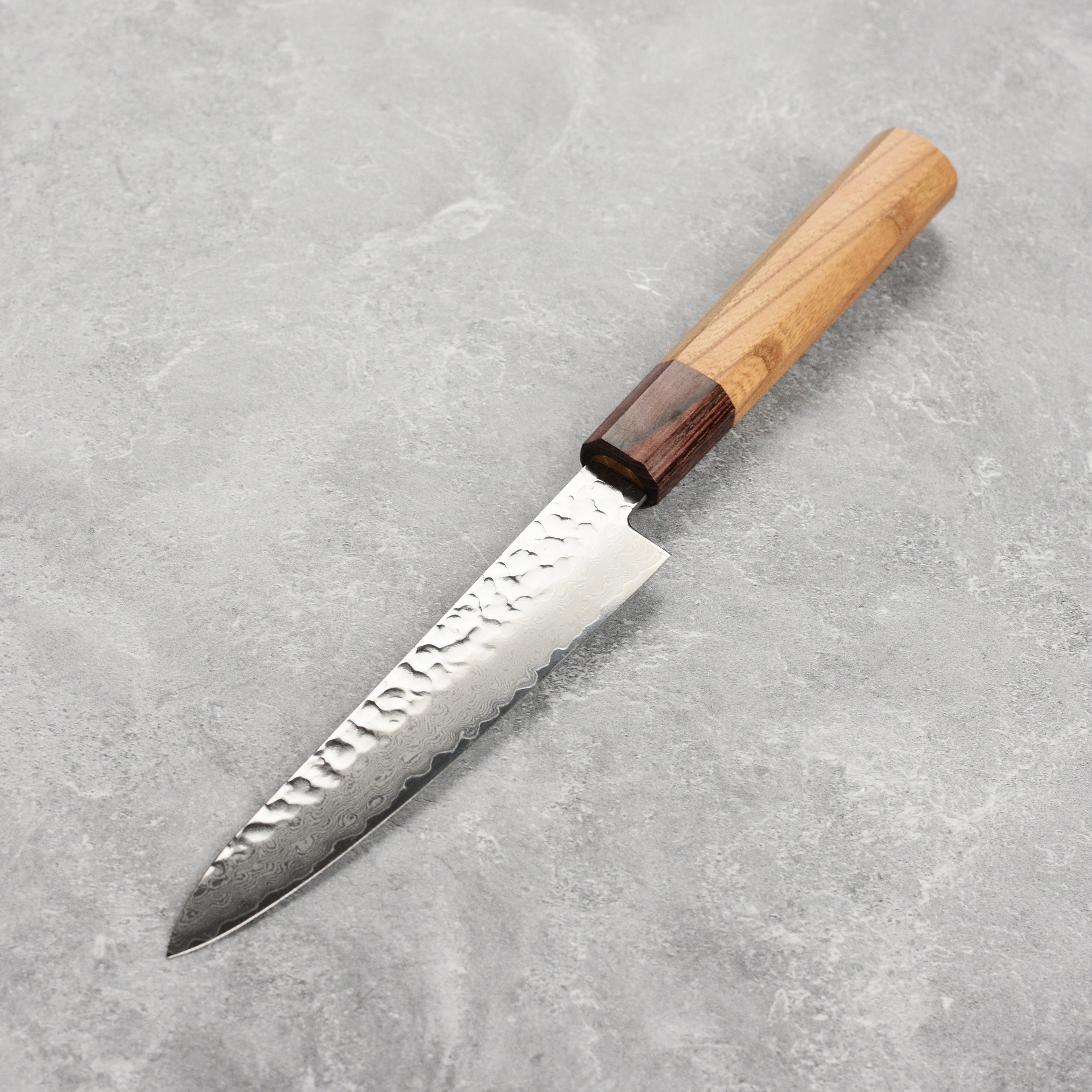 Octagonal Zelkova wood handle of the Japanese kitchen knife, showing the smooth finish and mahogany ferrule.