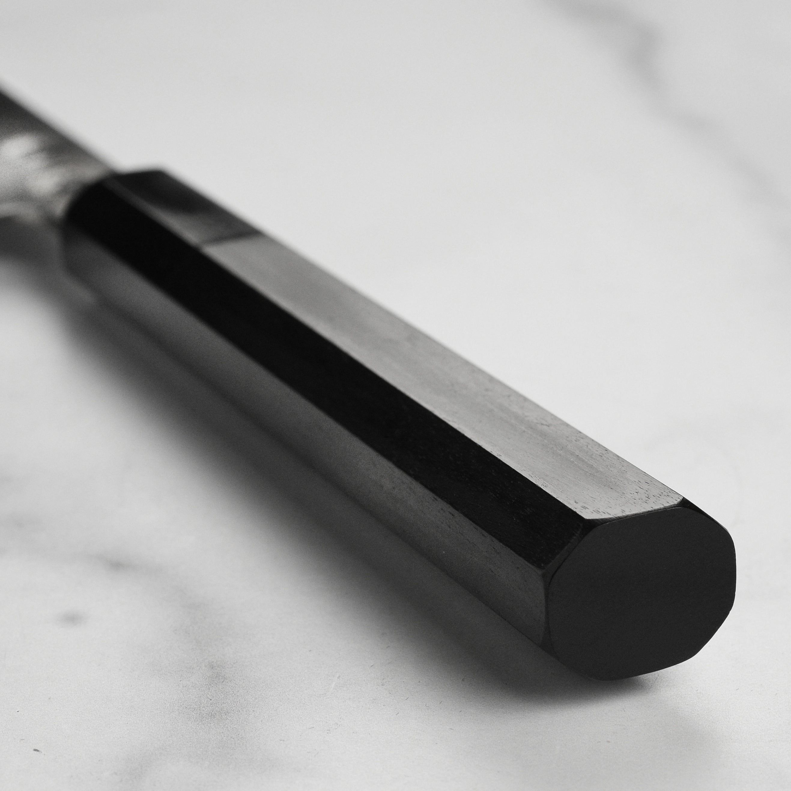 Sakai Ginsan Santoku knife in action, slicing fresh vegetables with precision.