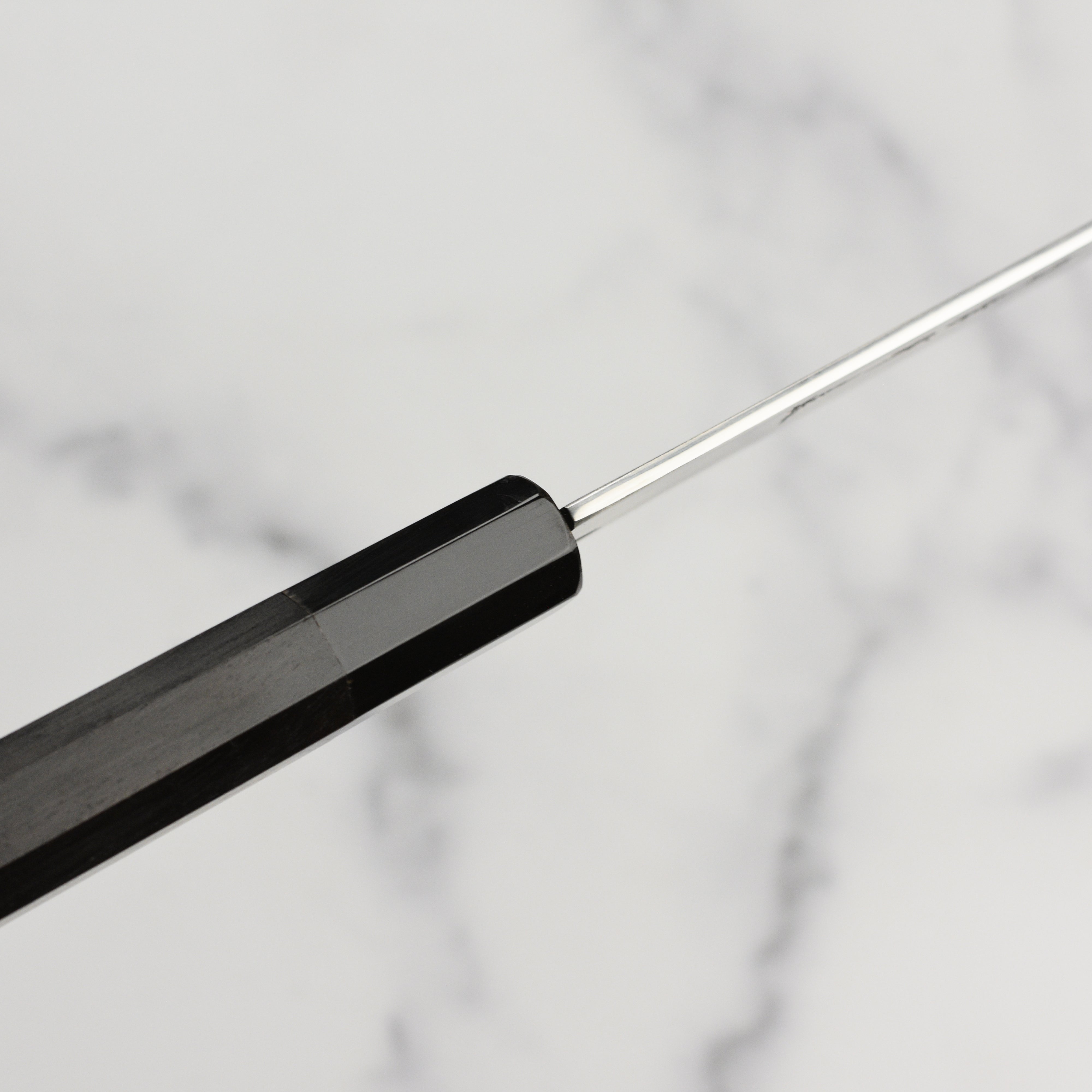 Close-up of the 62 Rockwell hardness Ginsan blade on a cutting board